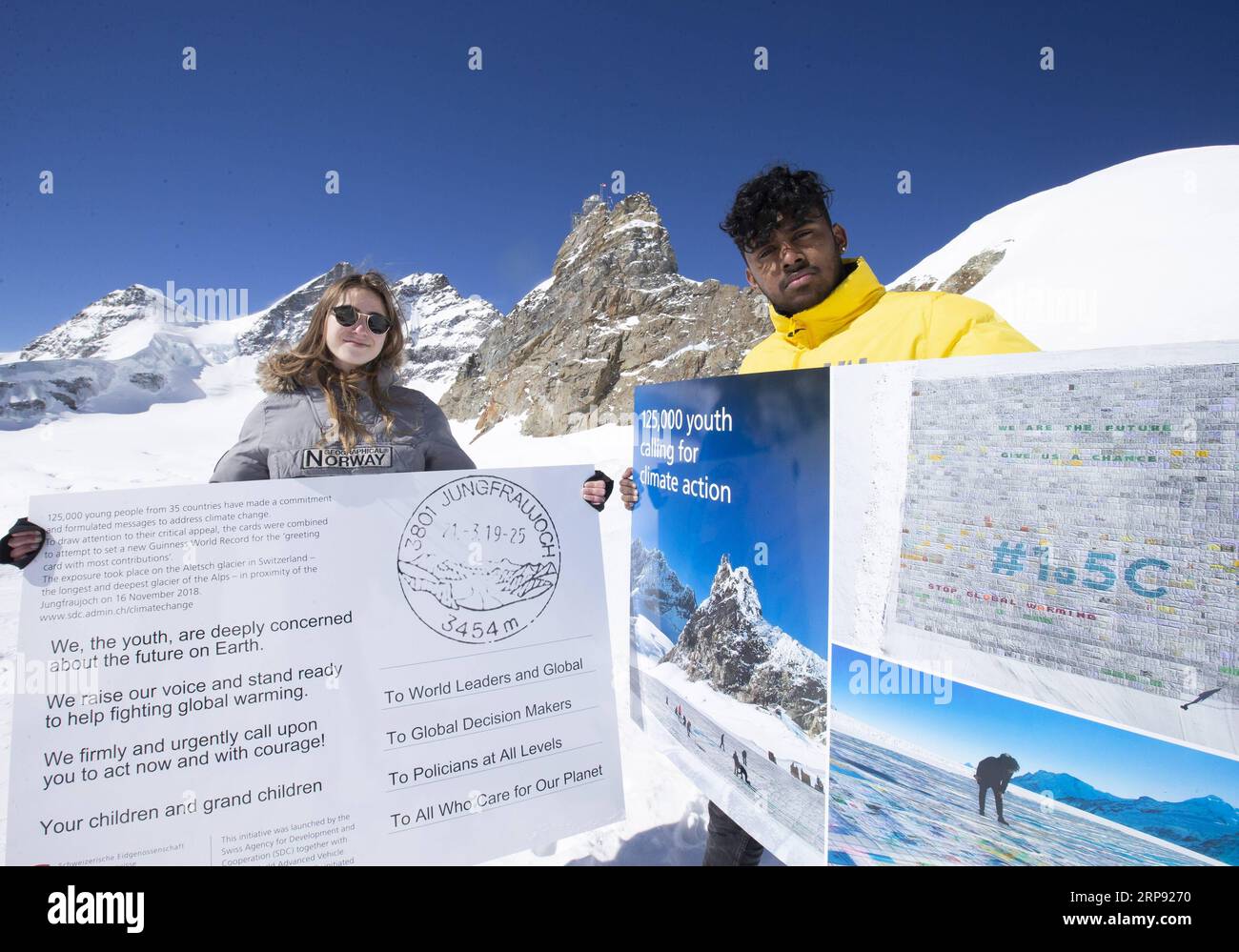 (190321) -- JUNGFRAUJOCH, March 21, 2019 (Xinhua) -- Swiss teenagers Sarangan Sivarajalingam (R) and Selma Schellenberg show copies of a postcard calling for action against climate change on the Aletsch glacier under Jungfraujoch in Switzerland, on March 20, 2019. Some 900 postcards from youths all over the world were stamped and sent on Wednesday from Europe s highest postbox on the Jungfraujoch peak, Switzerland, to global leaders, calling for action against climate change. (Xinhua/Xu Jinquan) SWITZERLAND-JUNGFRAUJOCH-CLIMATE CHANGE-POSTCARDS PUBLICATIONxNOTxINxCHN Stock Photo