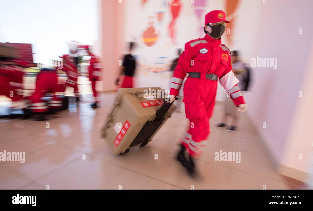 (190325) -- BEIRA (MOZAMBIQUE), March 25, 2019 (Xinhua) -- A Chinese rescue team member carries a suitcase of the newly-arrived equipment and materials at a temporary station in Beira, Mozambique, on March 25, 2019. A Chinese rescue team comprised of 65 members arrived at Beira International Airport in Mozambique on Monday after Cyclone Idai wreaked havoc in the southeastern African country. (Xinhua/Zhang Yu) MOZAMBIQUE-BEIRA-CYCLONE IDAI-CHINA-RESCUE TEAM-ARRIVAL PUBLICATIONxNOTxINxCHN Stock Photo
