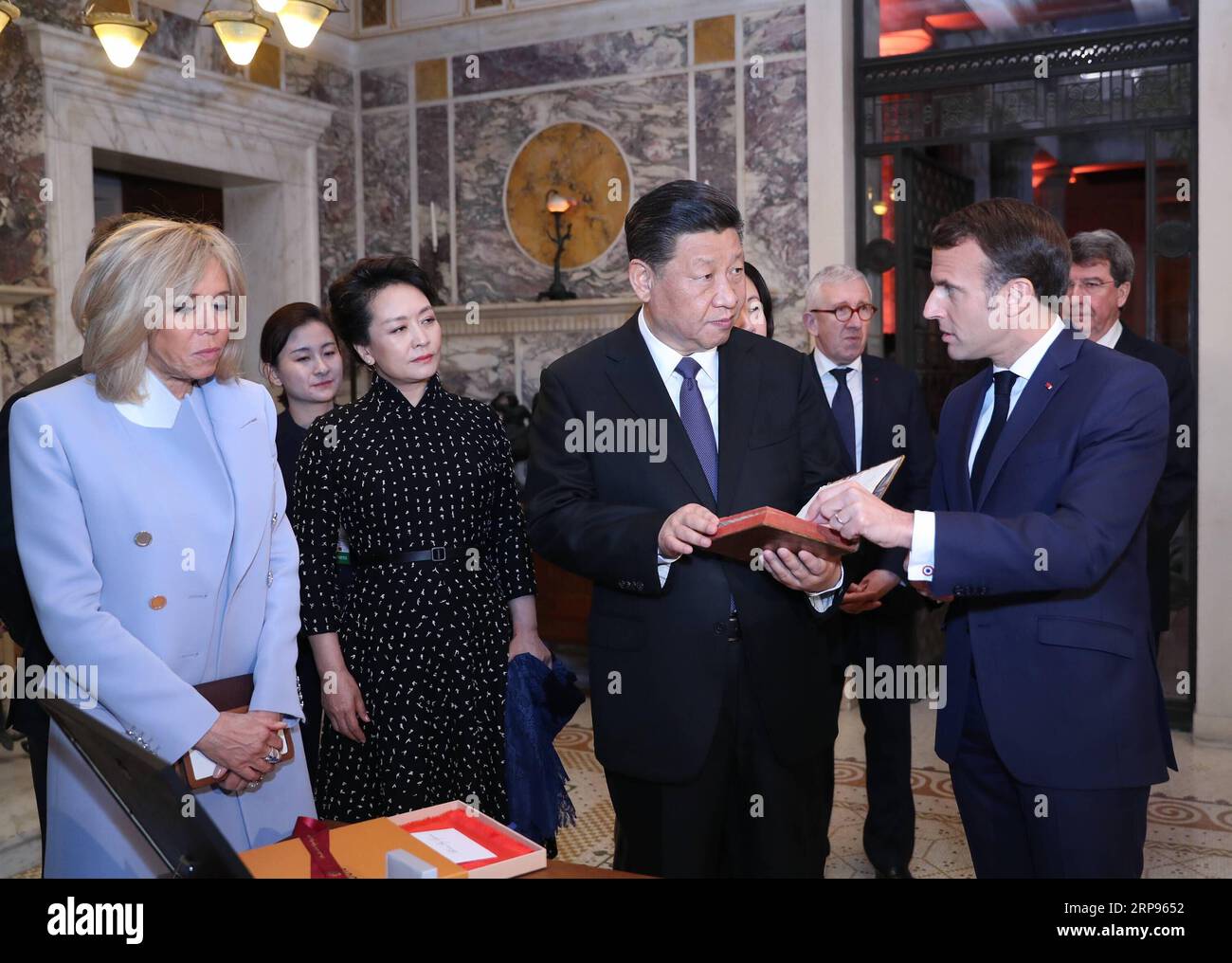 (190325) -- PARIS, March 25, 2019 -- Chinese President Xi Jinping (2nd R) receives the original French version of An Introduction to The Analects of Confucius , published in 1688, from his French counterpart Emmanuel Macron (1st R), as a national gift before their meeting in Nice, France, on March 24, 2019. ) FRANCE-NICE-CHINA-XI JINPING-MACRON-GIFT JuxPeng PUBLICATIONxNOTxINxCHN Stock Photo