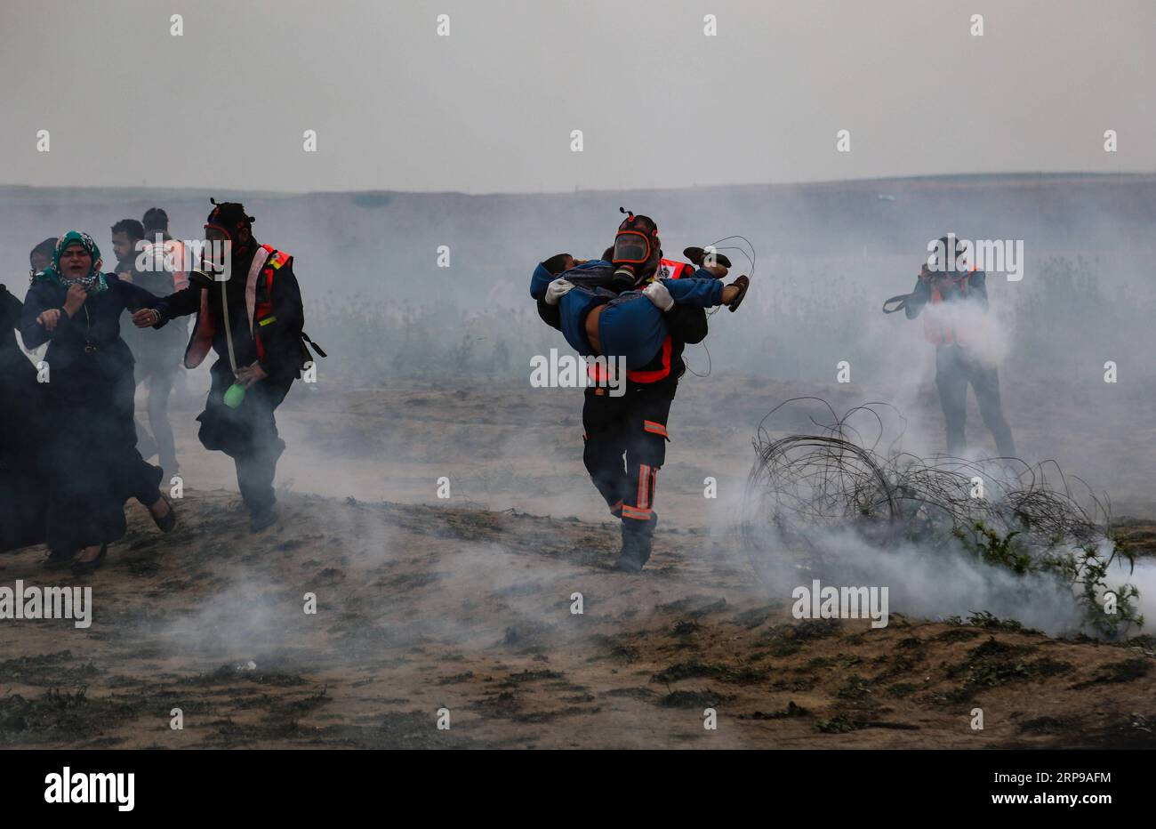 (190330) -- GAZA, March 30, 2019 () -- A Palestinian medic carries a wounded boy during clashes with Israeli troops on the Gaza-Israel border, east of Gaza City, March 30, 2019. At least three Palestinians were killed and 316 injured on Saturday during a day-long clashes with Israeli soldiers in eastern Gaza Strip, close to the border with Israel, medics said. The fierce clashes marked the first anniversary of the rallies, better known as the Great March of Return, and also 43 years for the Palestinian Land Day. () MIDEAST-GAZA-CLASHES Xinhua PUBLICATIONxNOTxINxCHN Stock Photo