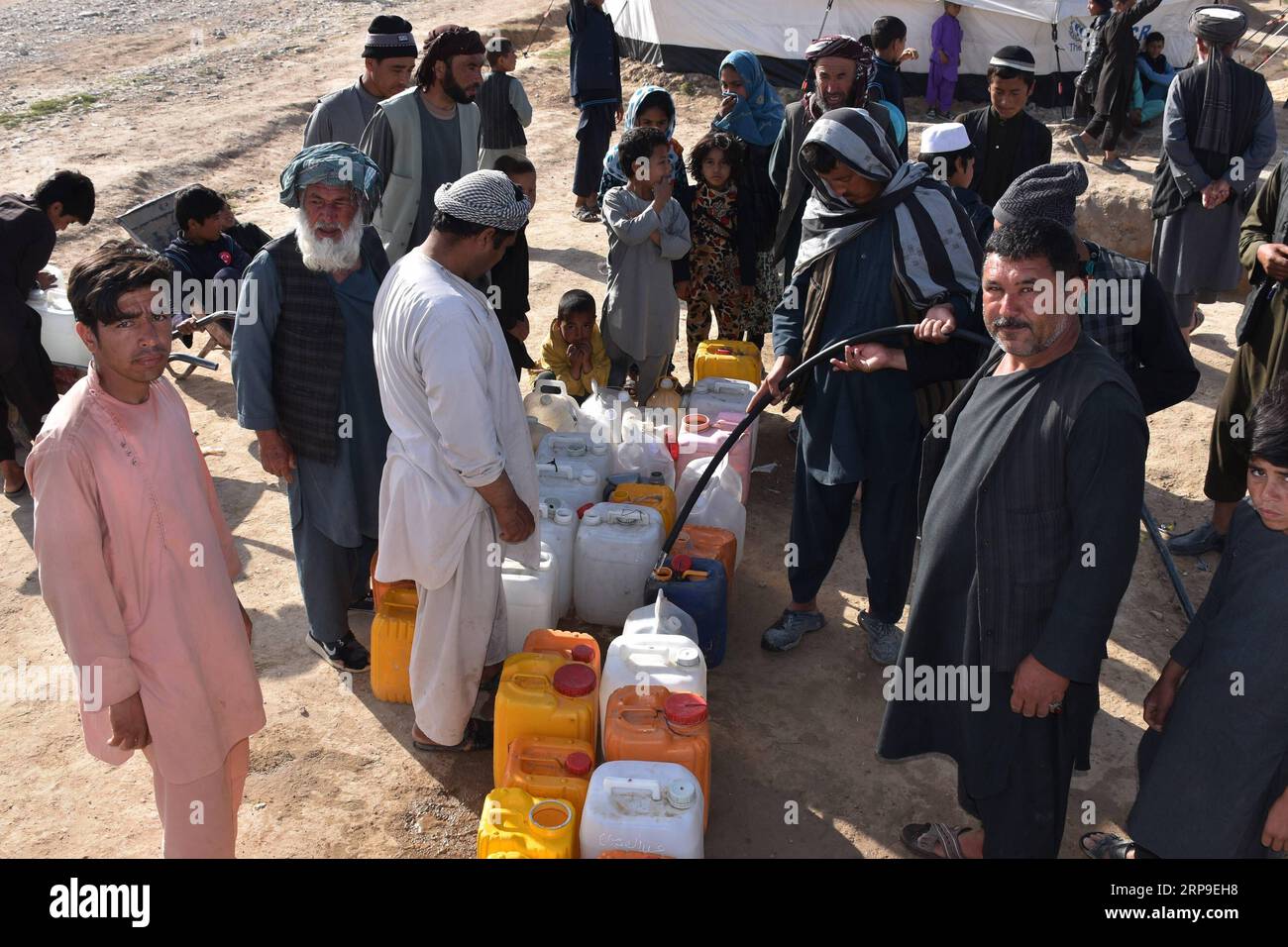(190404) -- BALKH, April 4, 2019 -- Displaced people receive water at a makeshift camp in Mazar-i-Sharif, capital of Balkh province, Afghanistan, April 4, 2019. More than 42,000 Afghans have been displaced following flooding in the country within the past one month and most needs supplies, the UN Office for the Coordination of Humanitarian Affairs (OCHA) reported on Wednesday. ) AFGHANISTAN-BALKH-FLOOD-DISPLACED KawaxBasharat PUBLICATIONxNOTxINxCHN Stock Photo