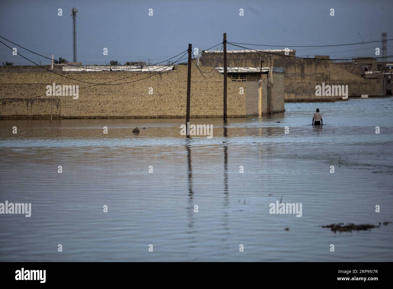 (190412) -- AHVAZ, April 12, 2019 -- A man wades through flood waters just outside Ahvaz city, capital of Khuzestan province, Iran, April 11, 2019. ) IRAN-AHVAZ-FLOOD AhmadxHalabisaz PUBLICATIONxNOTxINxCHN Stock Photo