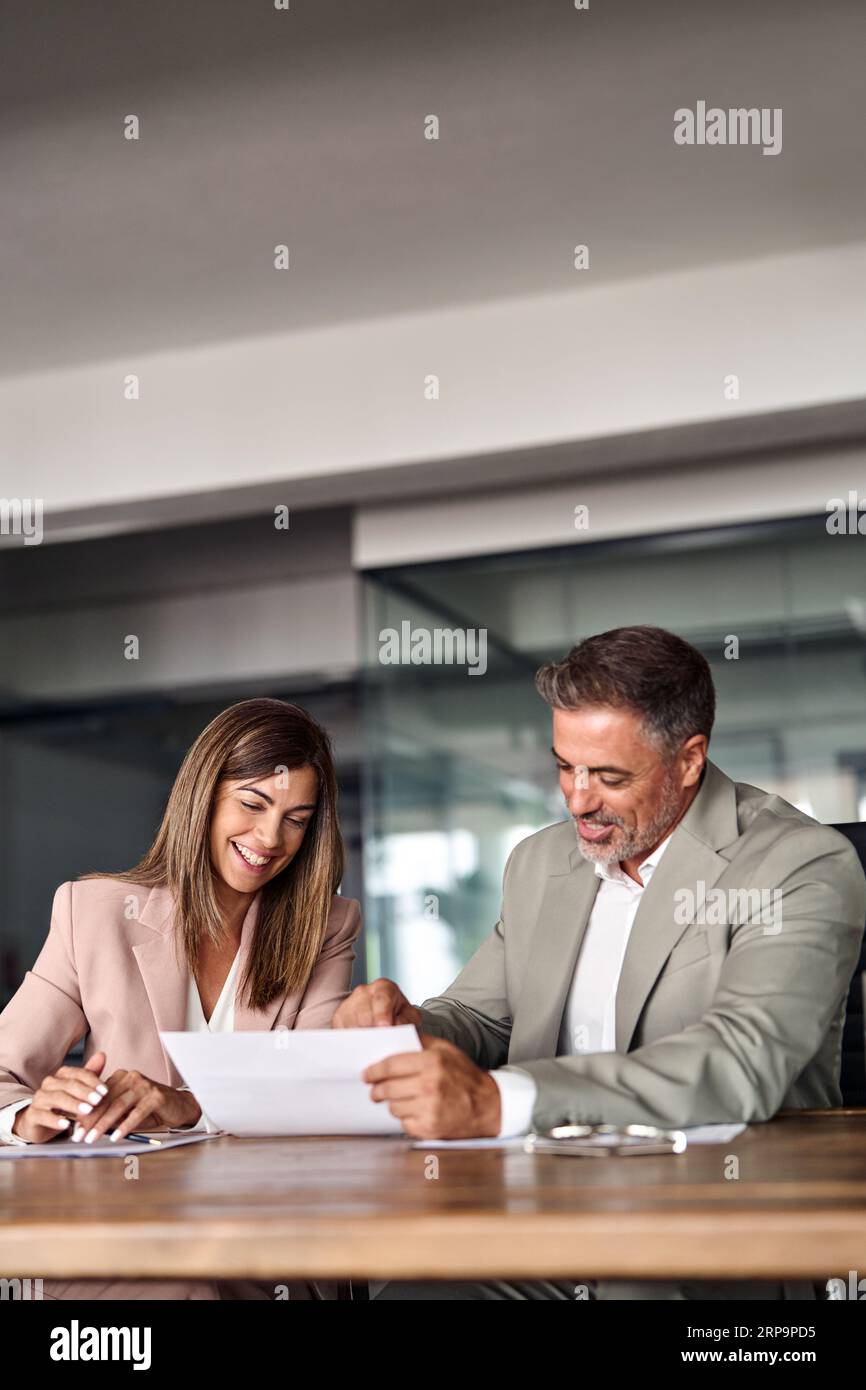 Two happy professional executives discussing financial documents in office. Stock Photo