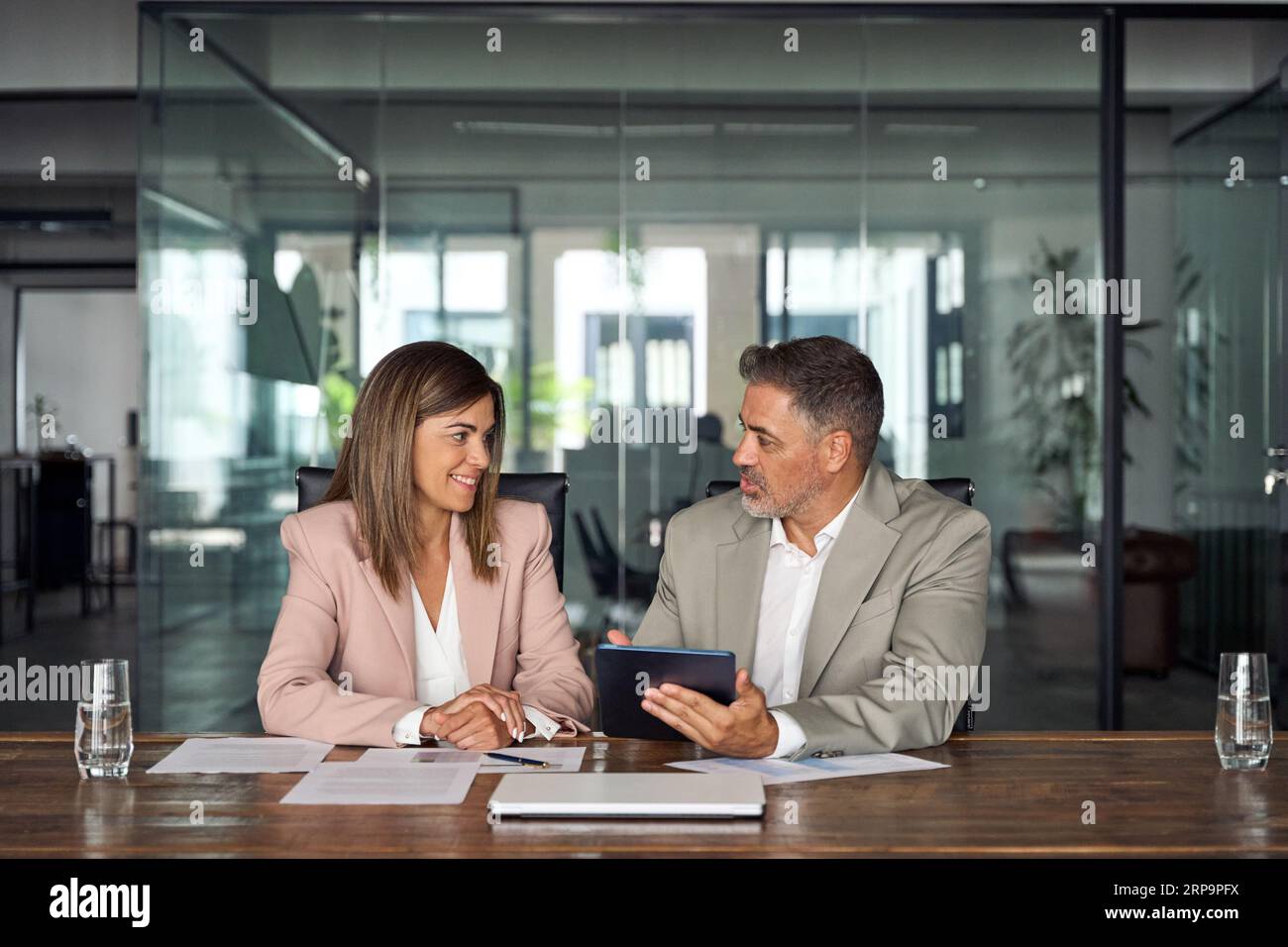 Two professional business executives working on tablet at office meeting. Stock Photo