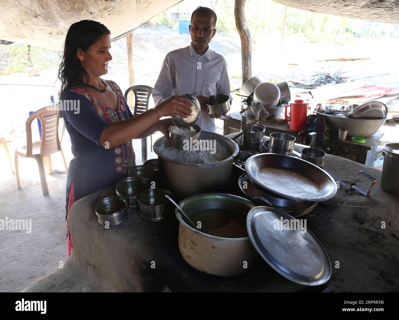 (190415) -- SURKHET, April 15, 2019 -- Laxmi Jaisi and her husband Lila Ram Acharya prepare food for workers at their hotel near the construction site of the tunnel for the Bheri Babai Diversion Multipurpose Project in Surkhet, west Nepal, March 26, 2019. Forty-six-year-old Lila Ram Acharya began to work in the Bheri Babai Diversion Multipurpose Project two years ago and his wife ran a hotel to serve meal to the project workers. The couple are well settled and economically benefited due to the China-constructed project. TO GO WITH Feature: Chinese irrigation project helps agriculture, offers e Stock Photo