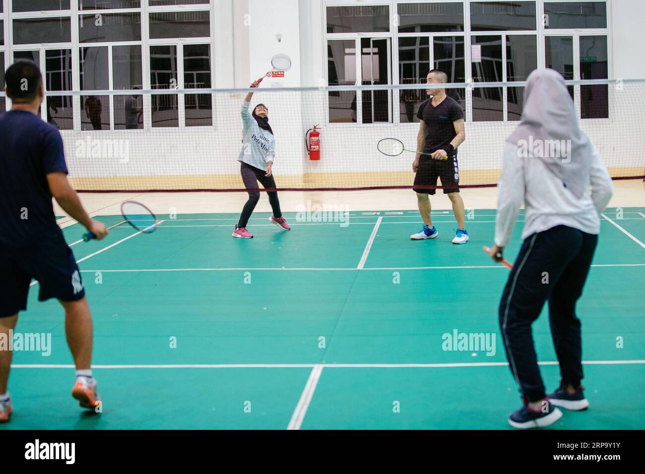 (190419) -- KUALA LUMPUR, April 19, 2019 (Xinhua) -- Nur Fatihah Binti Zakaria (L,back) plays badminton with her colleagues at the living area at the Malaysia-China Kuantan Industrial Park in Kuantan, Malaysia, April 15, 2019. At the beginning Malaysian college graduate Nur Fatihah Binti Zakaria had no idea about what steel production was all about, nor did she have any knowledge about speaking Chinese. But after almost two years working at the Alliance Steel at the Malaysia, China Kuantan Industrial Park, she now can perform her job skillfully, even making fun of her colleagues from China tha Stock Photo