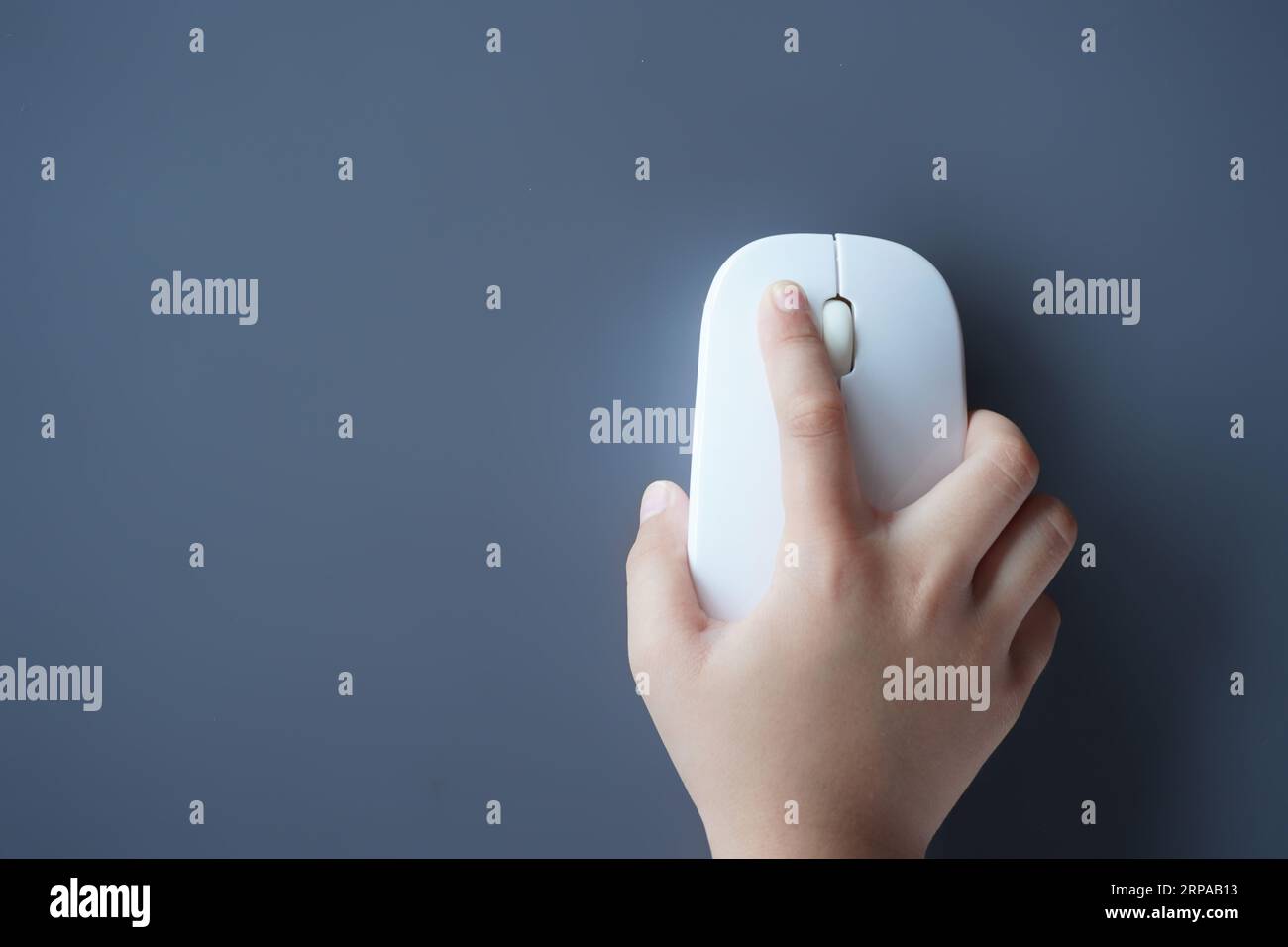 Top view image of small kid's hand using computer mouse. Copy space for text. Technology concept Stock Photo