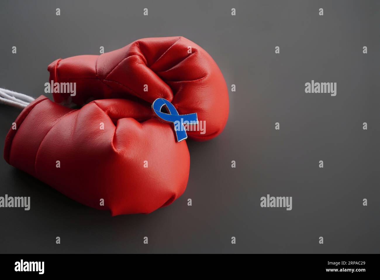 Close up image of boxing gloves and blue ribbon with copy space. Men's health, cancer awareness, stand against child abuse concept Stock Photo