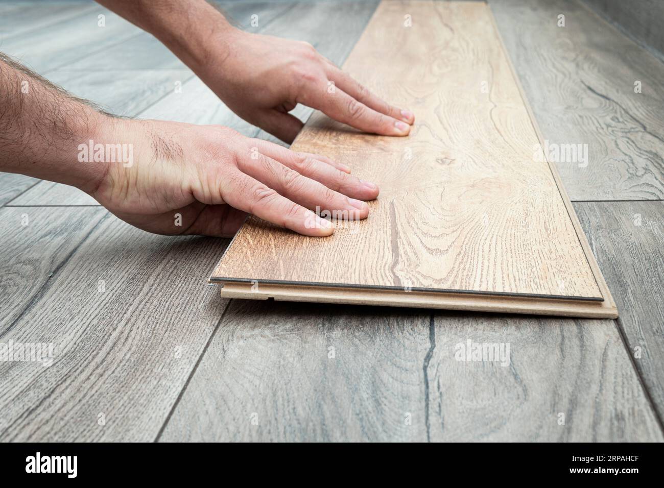 Close up of laminated flooring during replacing process. replacement of damaged laminate flooring. Renovation in the apartment. Choice of parquet Stock Photo