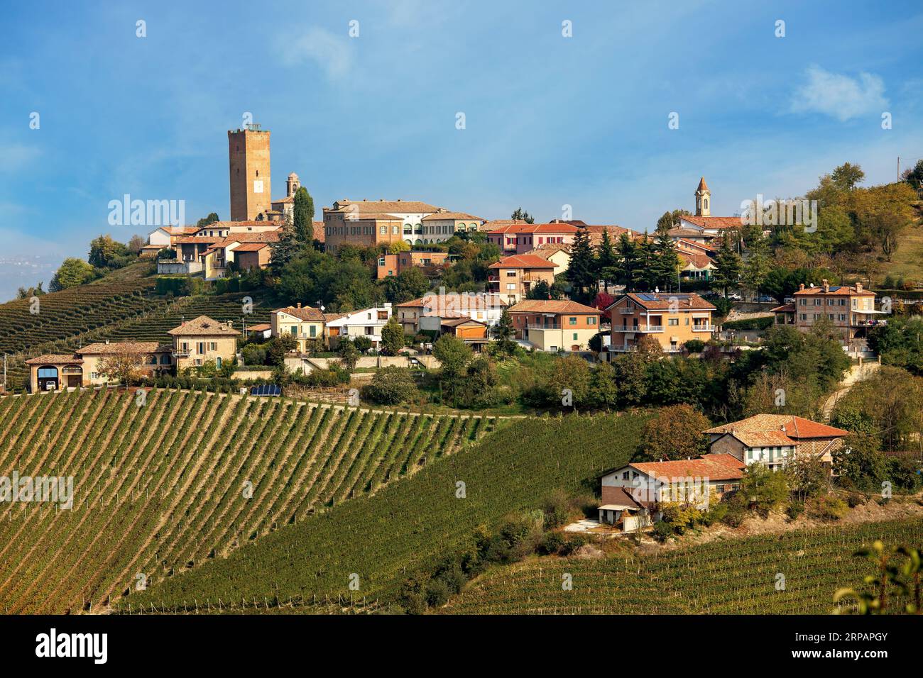 Small town on the hill with autumnal vineyards in Piedmont, Italy. Stock Photo