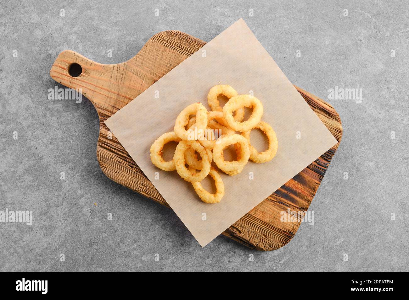 Top view of deep fried spicy onion rings on parchment Stock Photo