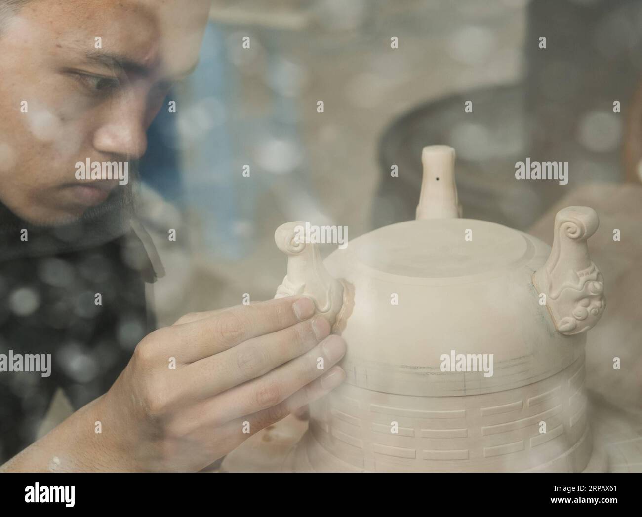 (190520) -- LONGQUAN, May 20, 2019 (Xinhua) -- Lin Song works on the clay base for a celadon incense burner at his studio in Longquan, east China s Zhejiang Province, May 20, 2019. Born in 1993, Lin Song is a native of Longquan, home to China s best celadon wares. He received professional training in both his hometown and Jingdezhen, another important porcelain hub of China. Lin had also followed other celadon artisans for years before setting up a studio back home in 2014, focusing on the replication of classical celadon incense burners. Lin s personal collection has grown to over 40 celadon Stock Photo
