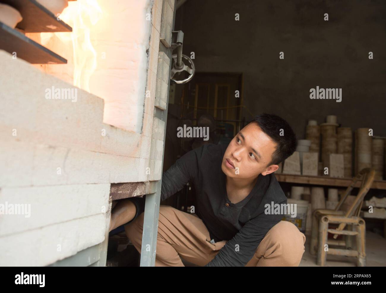 (190520) -- LONGQUAN, May 20, 2019 (Xinhua) -- Lin Song makes celadon incense burners using a gas kiln at his studio in Longquan, east China s Zhejiang Province, May 20, 2019. Born in 1993, Lin Song is a native of Longquan, home to China s best celadon wares. He received professional training in both his hometown and Jingdezhen, another important porcelain hub of China. Lin had also followed other celadon artisans for years before setting up a studio back home in 2014, focusing on the replication of classical celadon incense burners. Lin s personal collection has grown to over 40 celadon incen Stock Photo