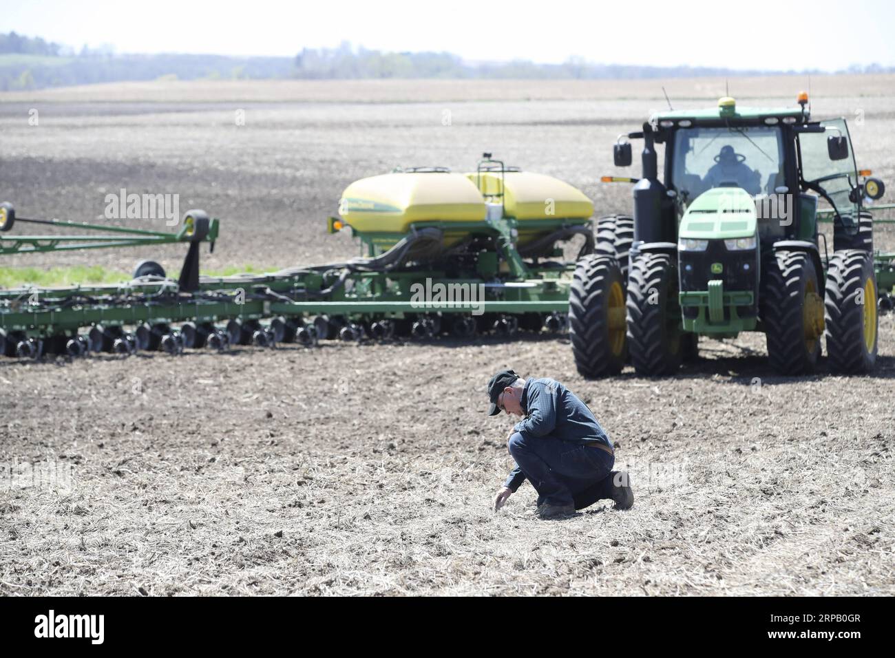 (190523) -- IOWA, May 23, 2019 (Xinhua) -- Bill Pellett examines the depth of the seeds after his son Bret plants corn with a planter machine at their family farm in Atlantic of Cass county, Iowa, the United States, April 24, 2019. Bill Pellett knows how to farm, but just like most of his peers across the country, the 71-year-old farmer is feeling less assured of what he could get from a new year of farming, as there appears to be no quick resolution of the year-long trade disputes between the United States and China. TO GO WITH Spotlight: Leading U.S. farming state enters new crop season amid Stock Photo