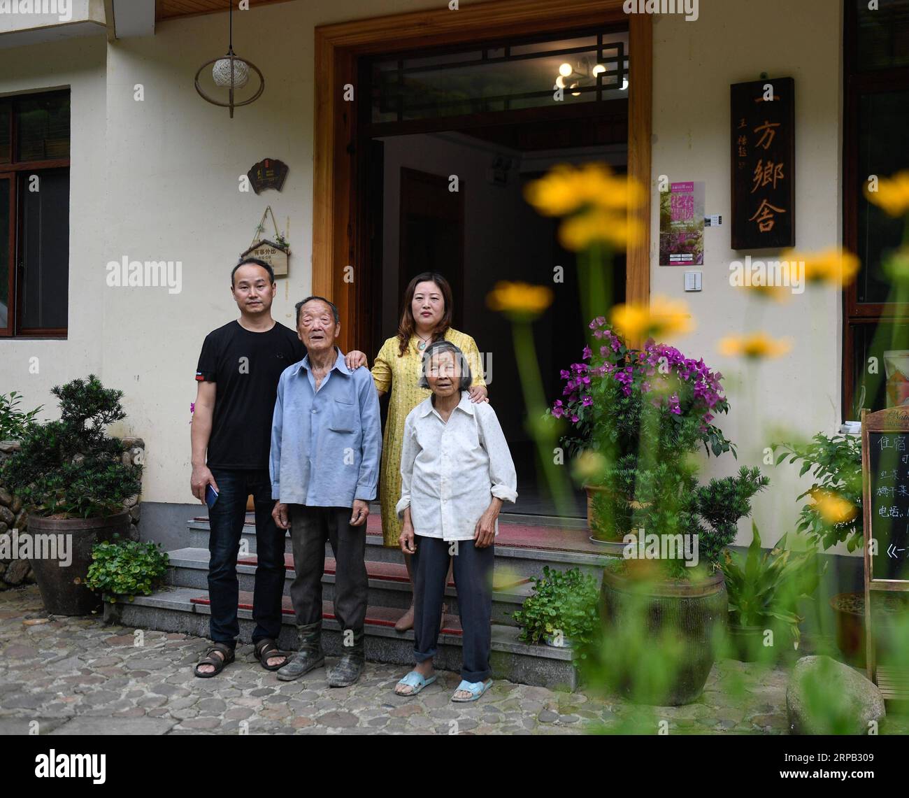 (190526) -- TONGLU, May 26, 2019 (Xinhua) -- Fang Dunwei (1st L), owners of a family inn, poses for a group photo with his family members at Shishe Village in Tonglu County, east China s Zhejiang Province, May 26, 2019. With remote location and beautiful scenery, Shishe Village is one of the three villages in Fuchun River slow rural life experience zone. In recent years, Shishe has repaired some ancient buildings. Cafes and homestays were also introduced here, which attracted a large number of tourists. In 2018, Shishe Village received more than 108,000 tourists, with a net income of more than Stock Photo