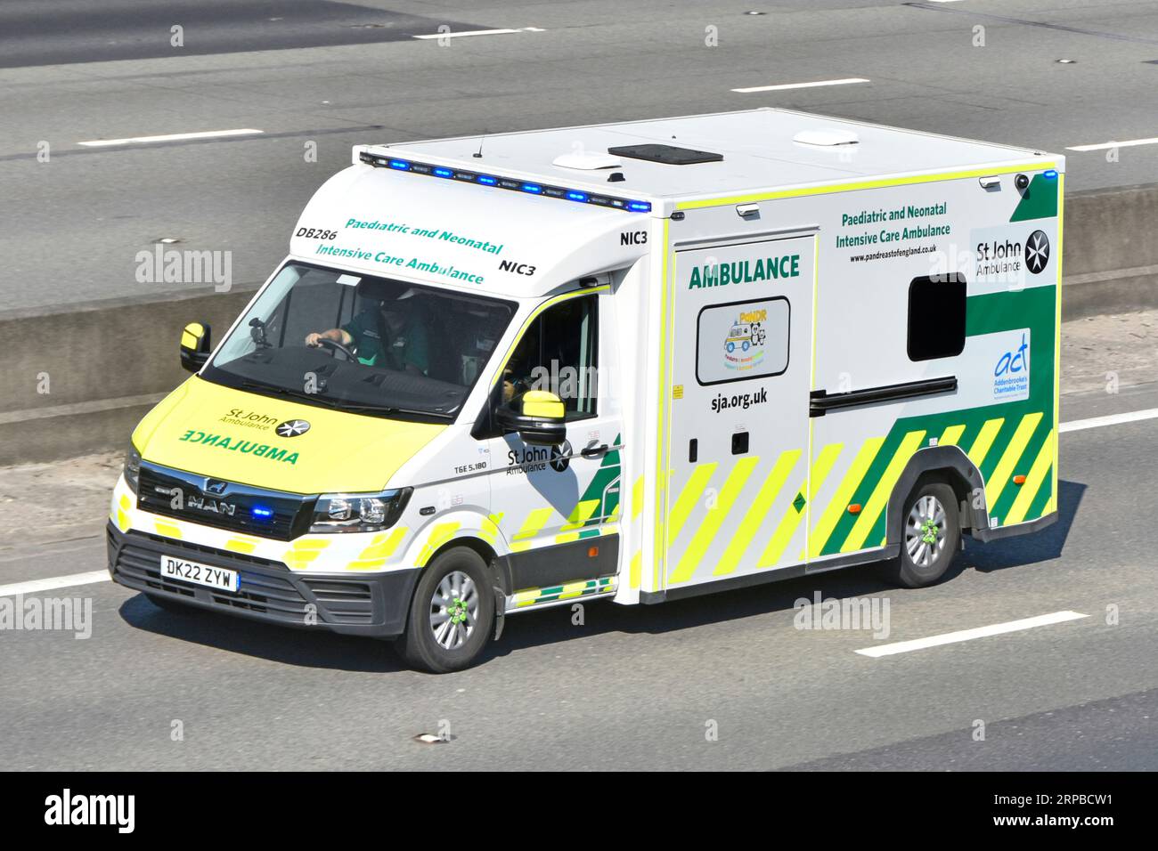 MAN TGE 5.180 van St John Paediatric and Neonatal Intensive Care Emergency Ambulance blue light journey in outside lane M25 motorway road England UK Stock Photo