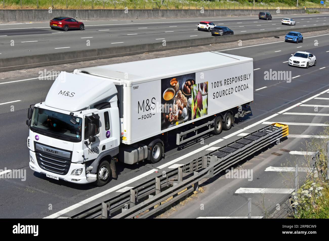 Aerial front side view Gist supply chain DAF hgv lorry truck M&S food business advert 100% responsibly sourced cocoa on semi trailer M25 motorway UK Stock Photo