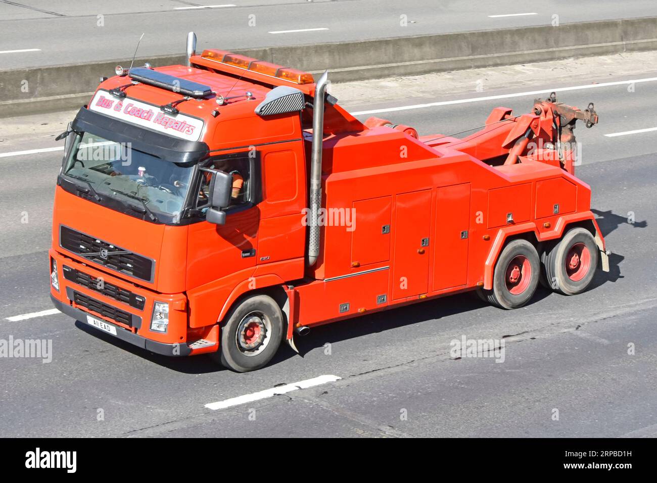 Looking down on clean red unmarked paint on bus & coach Volvo hgv lorry truck a commercial vehicle tow recovery breakdown business on M25 UK motorway Stock Photo