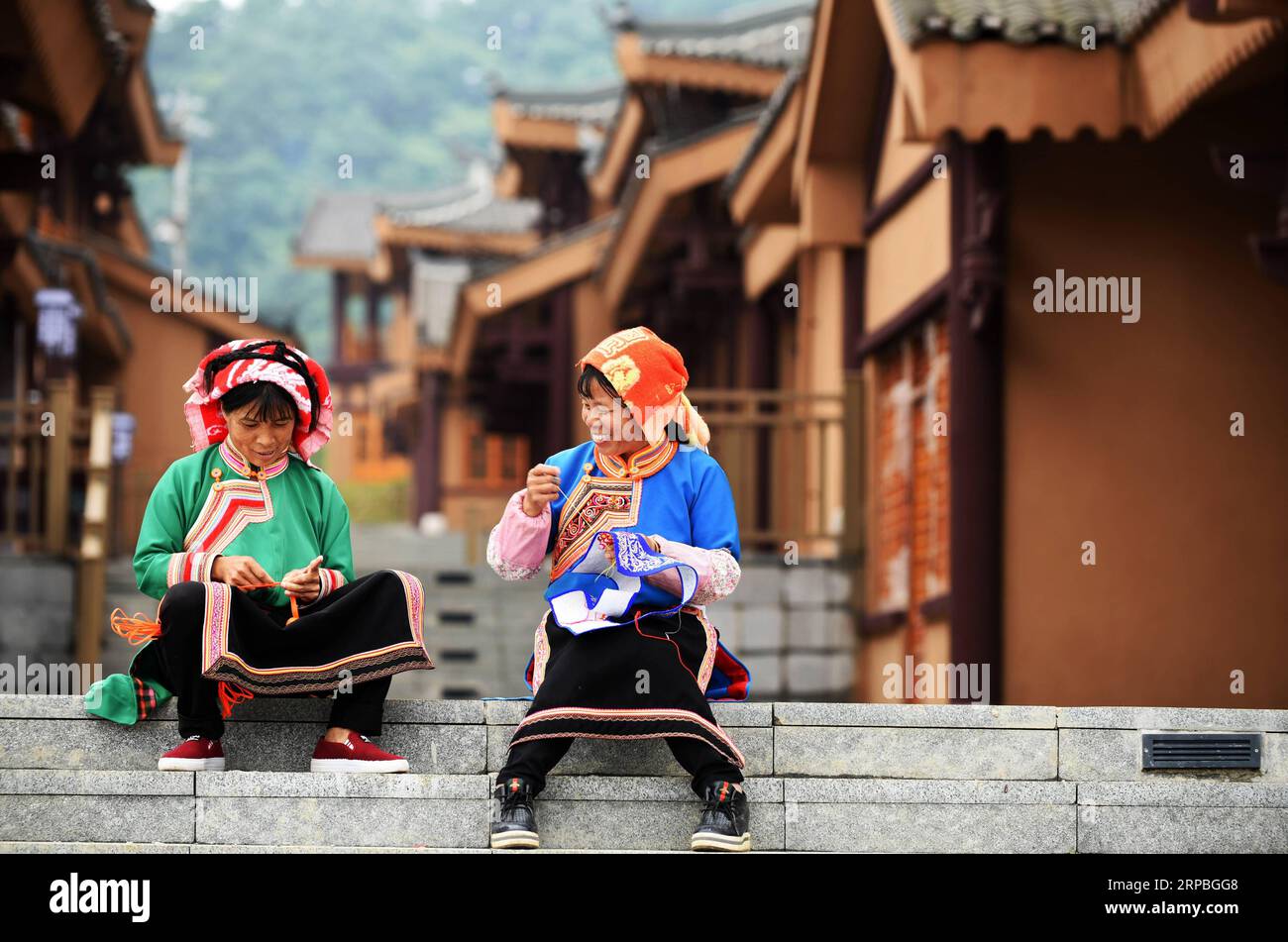 (190608) -- GUIYANG, June 8, 2019 (Xinhua) -- Villagers from Sanbao Town embroider in A-mei Qituo town of Qinglong County, southwest China s Guizhou Province, June 6, 2019. Leaving their shabby hillside dwellings built on steep slope, Sanbao s impoverished villagers embrace a better life. Poverty-stricken families in Sanbao Town have moved into new houses in A-mei Qituo town with the help of local government. (Xinhua/Yang Wenbin) CHINA-GUIZHOU-YI ETHNIC GROUP-TOWN-RELOCATION-A-MEI QITUO (CN) PUBLICATIONxNOTxINxCHN Stock Photo
