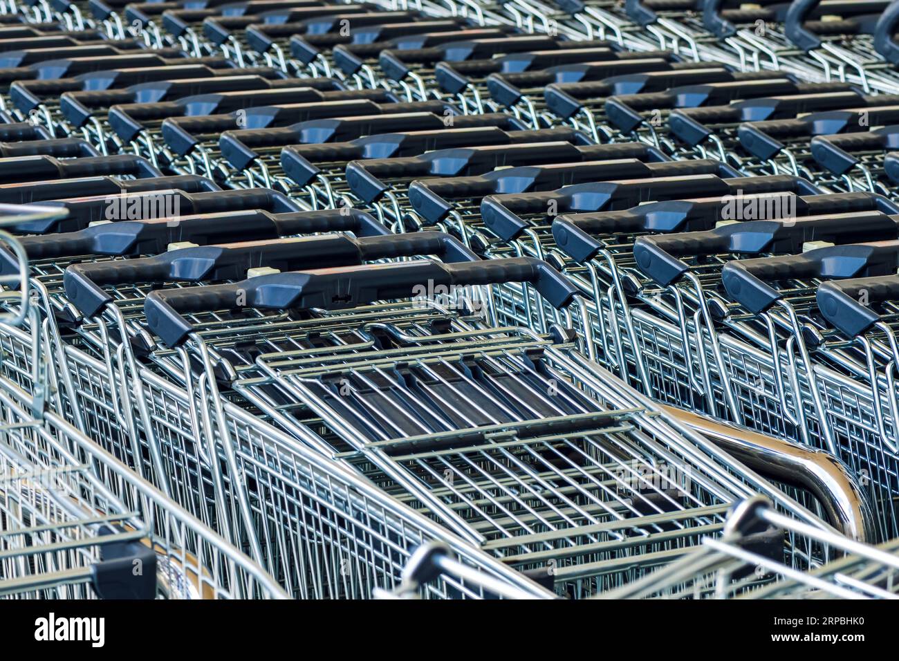 Stacked shopping trolley carts in front of the supermarket store, basket of goods concept, selective focus Stock Photo