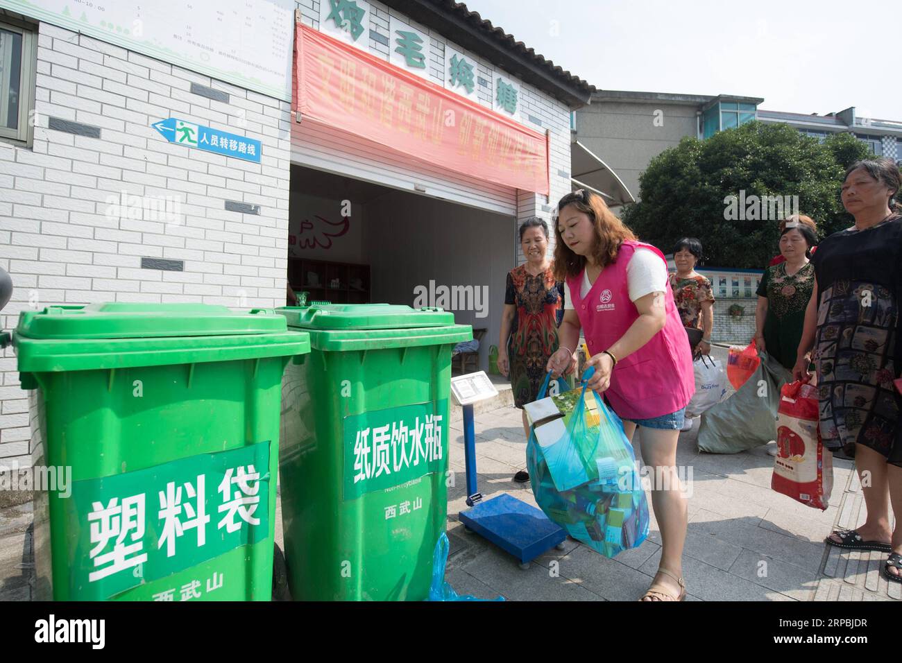 (190610) -- TONGLU, June 10, 2019 (Xinhua) -- A volunteer (front) helps farmers recycle garbage at a waste recycling point in Tonglu County, east China s Zhejiang Province, June 10, 2019. Farmers in five villages of Tonglu County can trade waste for books and daily necessities, as a way to promote garbage resorting and protect rural environment. (Xinhua/Weng Xinyang) CHINA-ZHEJIANG-TONGLU-GARBAGE SORTING (CN) PUBLICATIONxNOTxINxCHN Stock Photo