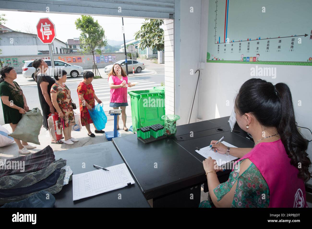 (190610) -- TONGLU, June 10, 2019 (Xinhua) -- Volunteers check garbage brought by farmers for recycling at a waste recycling point in Tonglu County, east China s Zhejiang Province, June 10, 2019. Farmers in five villages of Tonglu County can trade waste for books and daily necessities, as a way to promote garbage resorting and protect rural environment. (Xinhua/Weng Xinyang) CHINA-ZHEJIANG-TONGLU-GARBAGE SORTING (CN) PUBLICATIONxNOTxINxCHN Stock Photo