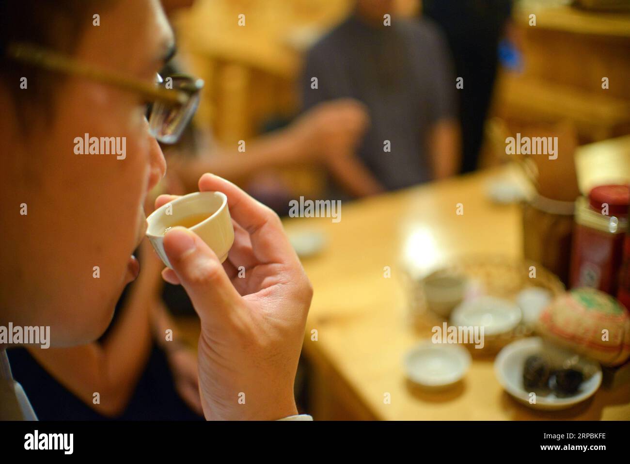 (190611) -- KUALA LUMPUR, June 11, 2019 (Xinhua) -- A man tastes tea at Ricky Heng s teahouse in Kuala Lumpur, Malaysia, May 24, 2019. Ricky Heng, 51, is a tea master from Kuala Lumpur, Malaysia. He used to be a photojournalist, often carrying 6 or 7 kilograms of equipment to do 4 or 5 works every day. What Ricky Heng did not expect is that his life has been completely changed because of the Chinese tea. After starting to drink Chinese tea, Ricky Heng s life slowed down gradually. When he drinks tea, he says, he enters a state of tea meditation, a state that makes people settle down, feeling l Stock Photo