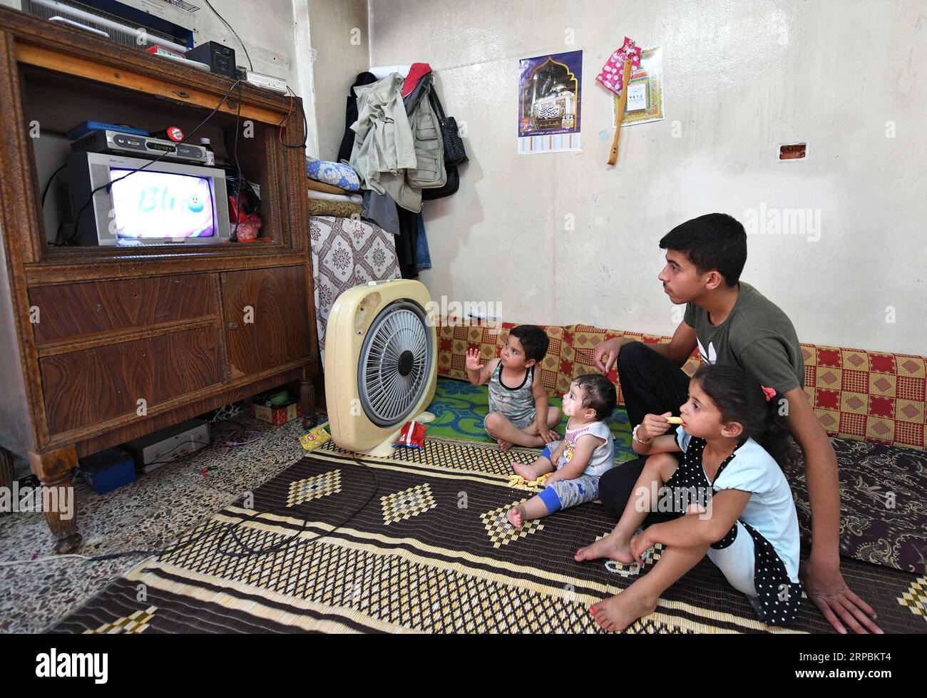 (190611) -- HOMS, June 11, 2019 -- Children of Kamal Shtaiwi watch TV in their house in the Wadi al-Sayeh street in the central city of Homs, Syria, May 29, 2019. Kamal Shtaiwi, 58, enjoys returning to his home with his wife and four children, even though it is surrounded by the destruction of war. TO GO WITH Feature: Displaced Syrian family back home, sweet home amid rubble ) SYRIA-HOMS-DISPLACED SYRIAN FAMILY-HOME AmmarxSafarjalani PUBLICATIONxNOTxINxCHN Stock Photo