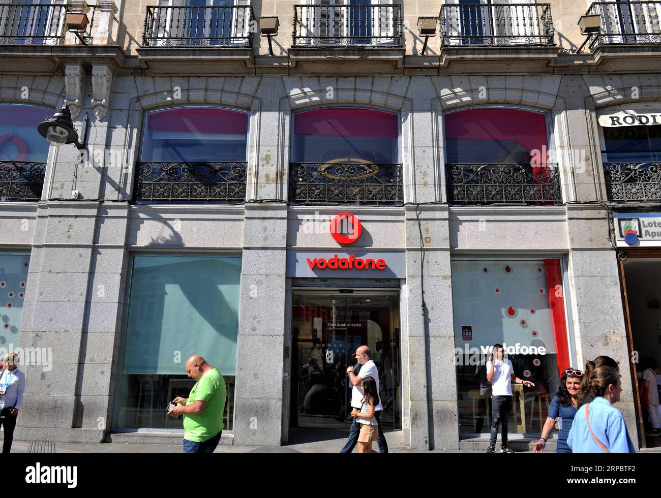 (190615) -- MADRID, June 15, 2019 (Xinhua) -- Pedestrians walk past a store of Vodafone Espana in Madrid, Spain, on June 15, 2019. In cooperation with Chinese telecom giant Huawei, Vodafone Espana on Saturday rolled out the first commercial 5G mobile services in Spain, making it one of the first European countries with the ultrafast mobile network in Europe. (Xinhua/Guo Qiuda) SPAIN-MADRID-VODAFONE-HUAWEI-FIRST 5G NETWORK PUBLICATIONxNOTxINxCHN Stock Photo