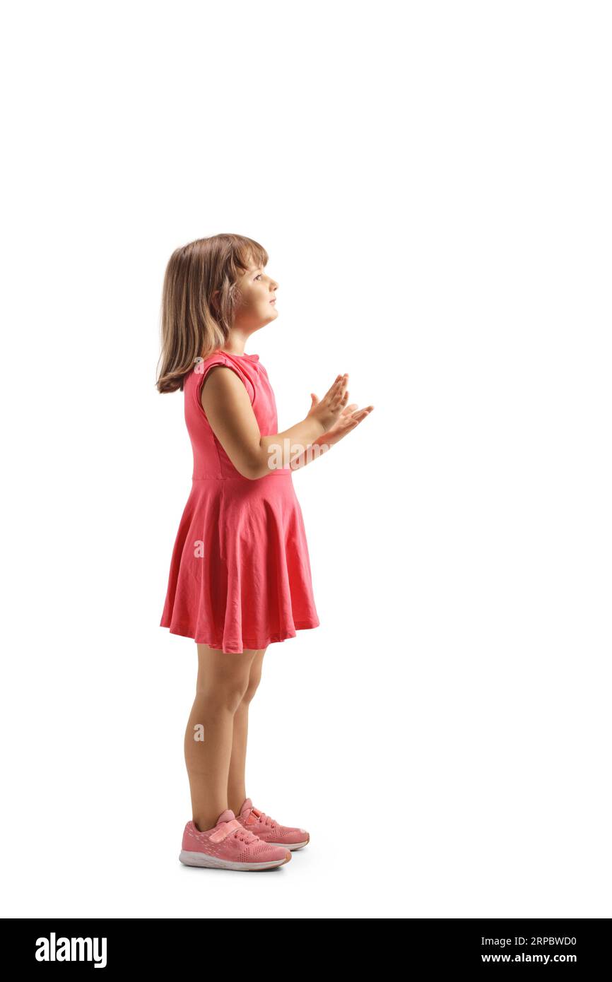 Full length profile shot of a little girl clapping with hands isolated on white background Stock Photo