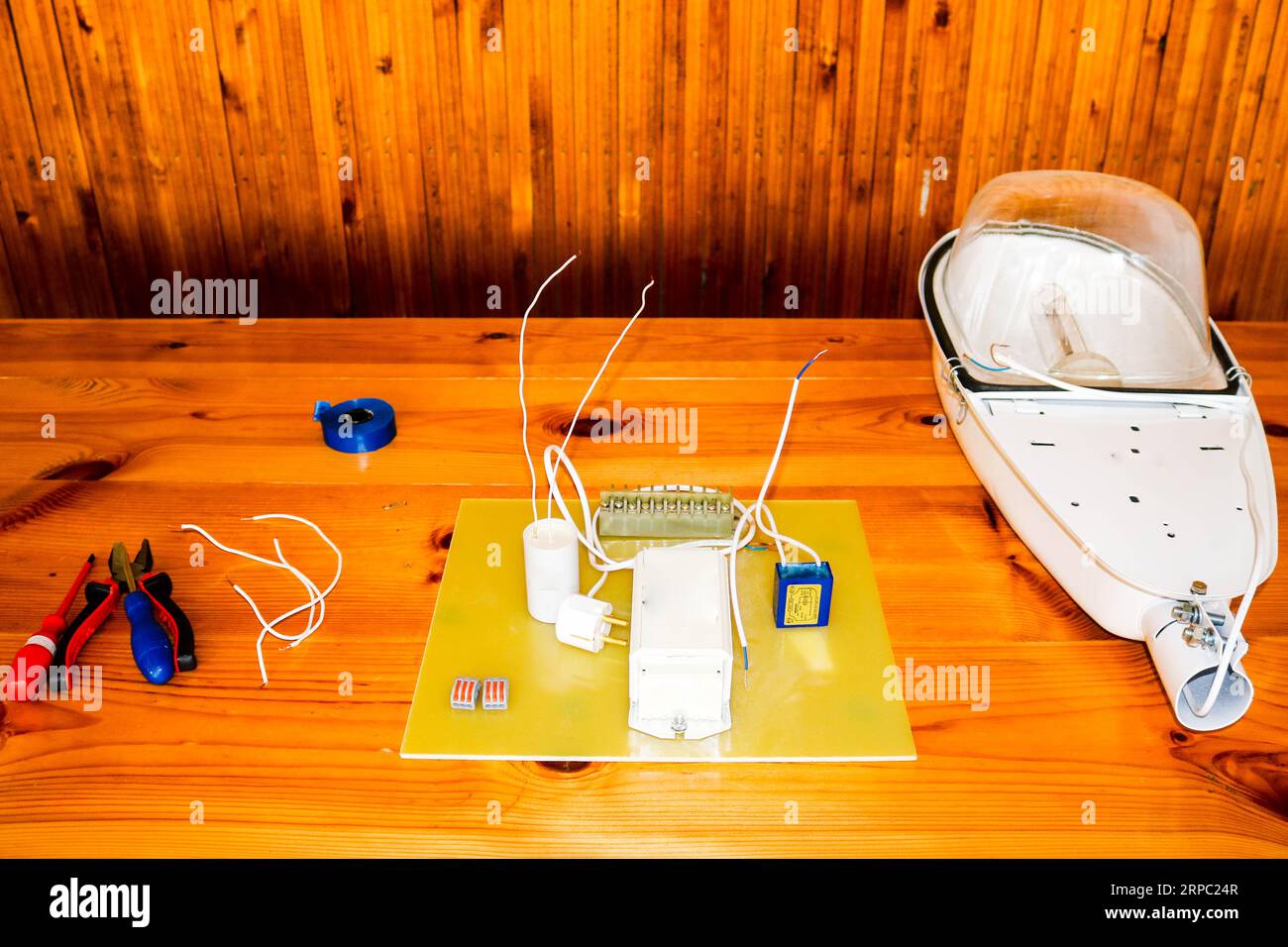 A large white disassembled street lamp with an electrical circuit with