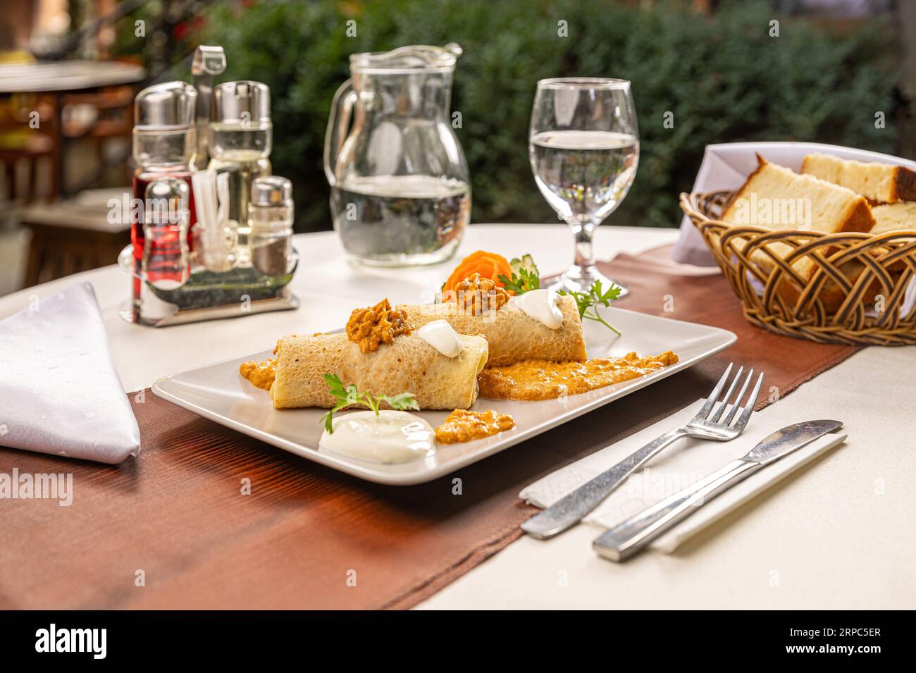 Savory pancake rolls stuffed with ground meat serving on the restaurant