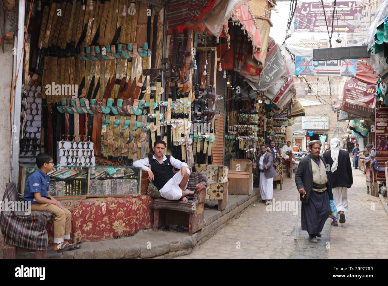 (190626) -- SANAA, June 26, 2019 (Xinhua) -- Jambiya shops are seen in the Old City of Sanaa, Yemen, on June 26, 2019. The Yemenis have not been affected by the Western stylish changes as they still proudly keep their ancestors traditional dress, especially the wear of the horn-handle knife Jambiya for nearly 3,000 years. Jambiya is a specific dagger with a T-shaped handle made from rhinoceros horns or other animals bones and decorated with gold and other precious metals, and a short and curved double-edged knife. (Xinhua/Mohamed al-Azaki) TO GO WITH Feature: Horn-handle knife Jambiya symboliz Stock Photo