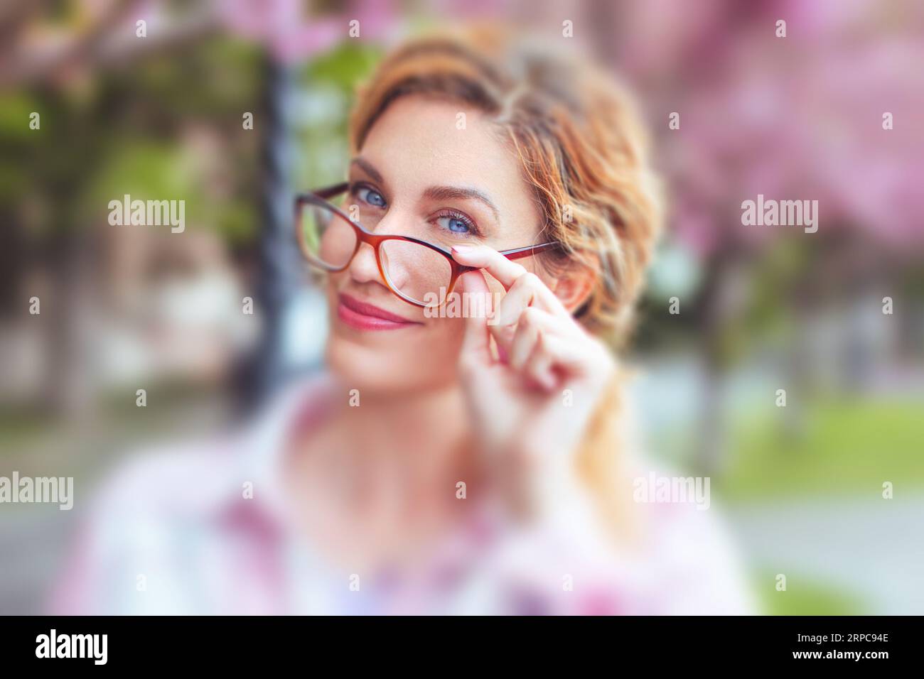 Caucasian woman holding eyeglasses, due to  vision correction in park Stock Photo