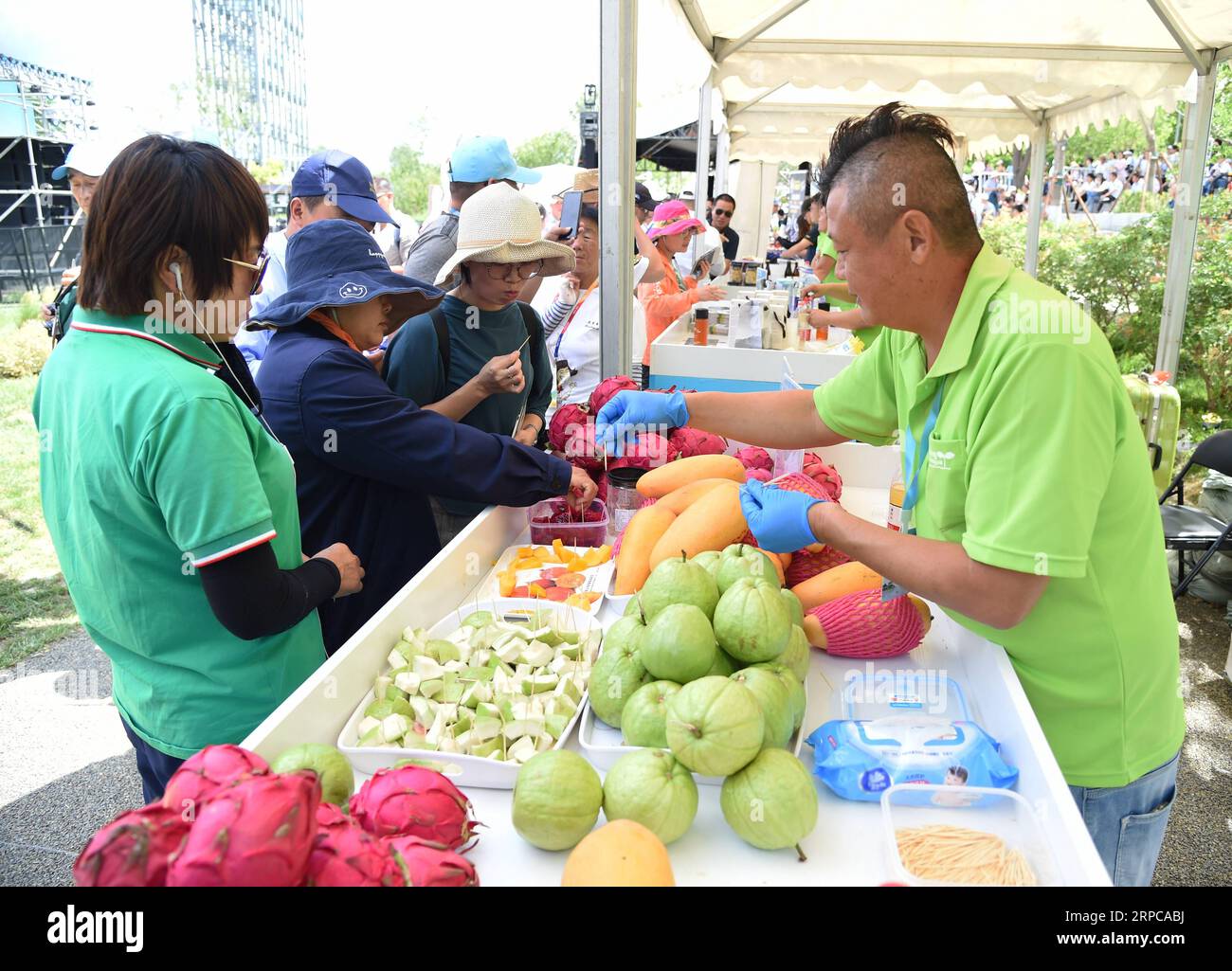 (190629) -- BEIJING, June 29, 2019 -- Tourists taste fruits at the Taiwan Garden during the Taiwan Day event at the Beijing International Horticultural Exhibition in Yanqing District of Beijing, capital of China, June 29, 2019. The ongoing Beijing International Horticultural Exhibition ushered in Taiwan Day event on Saturday. ) CHINA-BEIJING-HORTICULTURAL EXPO-TAIWAN (CN) RenxChao PUBLICATIONxNOTxINxCHN Stock Photo