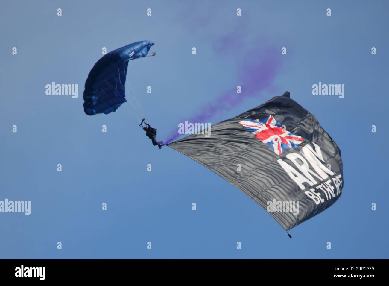 The Army parachute team flying a flag advertising the army ' Be the best' at the Bournemouth Air Festival 2023, Bournemouth, UK Stock Photo