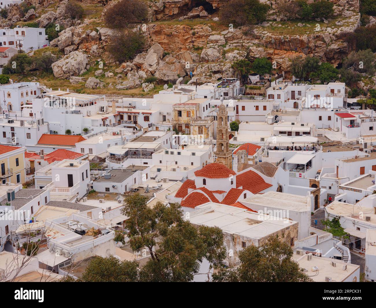 Lindos town in Greece aerial view in cloud summer day, white houses in Rhodes island , cityscape viewpoint traditional greek architecture, famous land Stock Photo