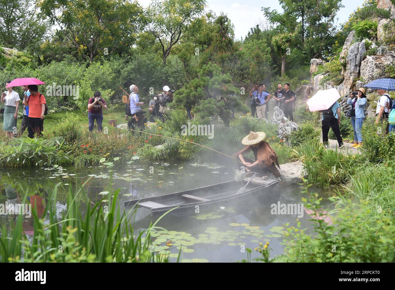 (190708) -- BEIJING, July 8, 2019 -- Tourists visit the Hunan Garden at the Beijing International Horticultural Exhibition in Beijing, capital of China, July 7, 2019. Located in central China, Hunan Province is well-known for its varied topography. It abuts the Dongting Lake to the north, and the east, south and west sides of the province are surrounded by mountains, with Wuling and Xuefeng Mountains to the west, Nanling Mountain to the south, Luoxiao and Mufu Mountains to the east. The Xiangjiang, Zijiang, Yuanjiang and Lishui Rivers converge on the Yangtze River at the Dongting Lake in the n Stock Photo