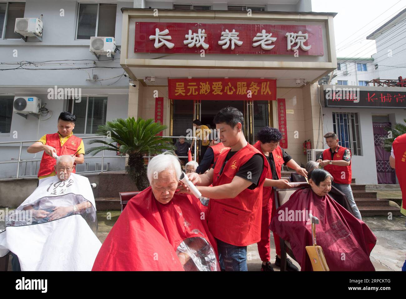 (190708) -- LINHAI, July 8, 2019 -- Volunteers cut hair for free at a nursing home for the aged in Linhai City, east China s Zhejiang Province, June 27, 2019. Wu Yuanmiao, when working as a barber, set a rule for himself to provide free service one day a week to the old, the disabled, and soldiers. Having served more than 60,000 customers for 17 year, he is the winner of various awards including May 1 Labor Medal. However, diagnosed with brain disease, Wu s condition has been worse off since 2008. In 2014, he experienced a hard time in running his barber shop and providing public service, thus Stock Photo
