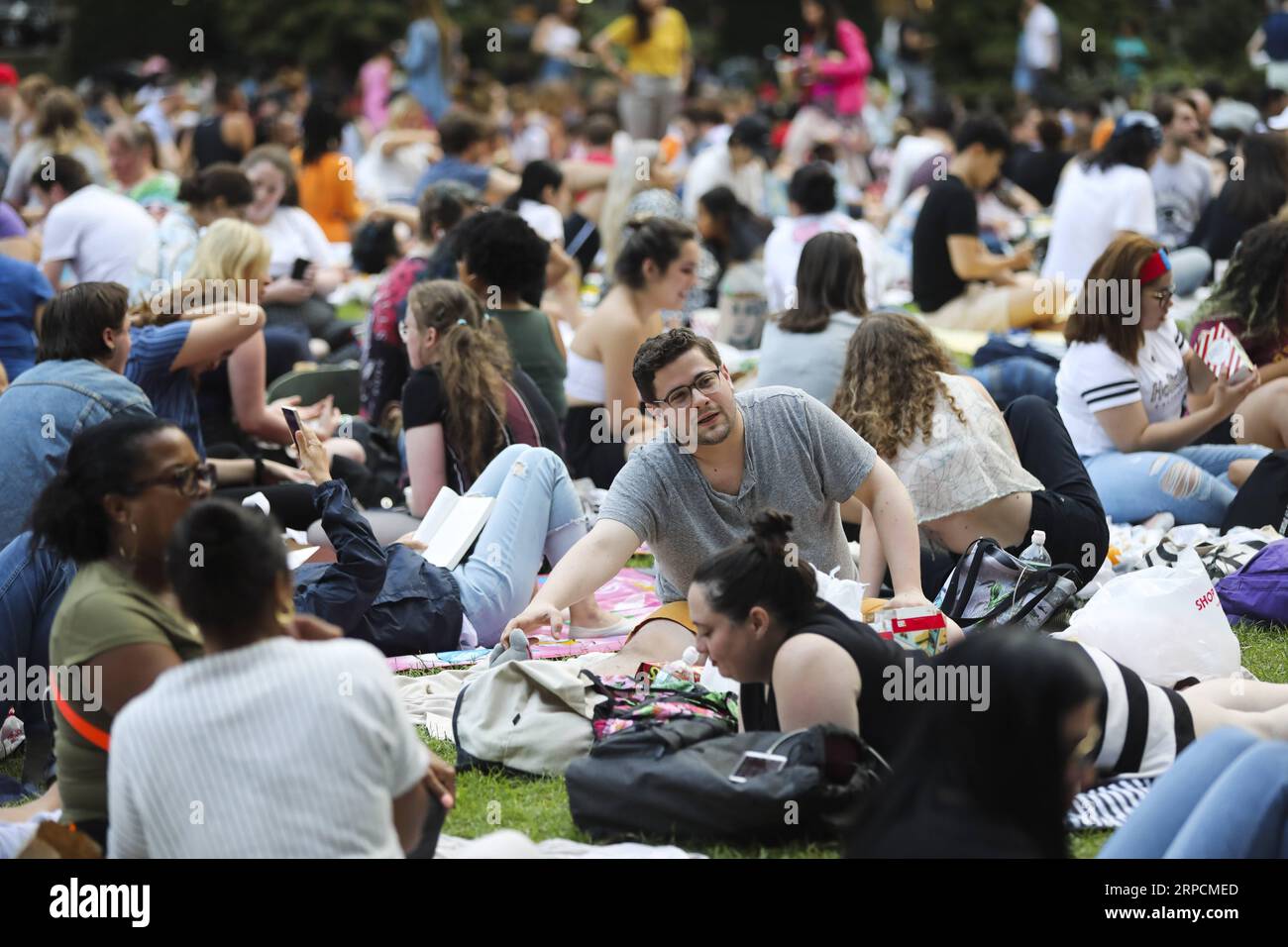 (190709) -- NEW YORK, July 9, 2019 -- People wait for the start of an outdoor movie show in Bryant Park in New York, the United States, July 8, 2019. As summer comes, outdoor and indoor movie screening events are quite popular all over the city, attracting thousands of people to enjoy their summer nights. ) U.S.-NEW YORK-OUTDOOR MOVIE SHOW WangxYing PUBLICATIONxNOTxINxCHN Stock Photo