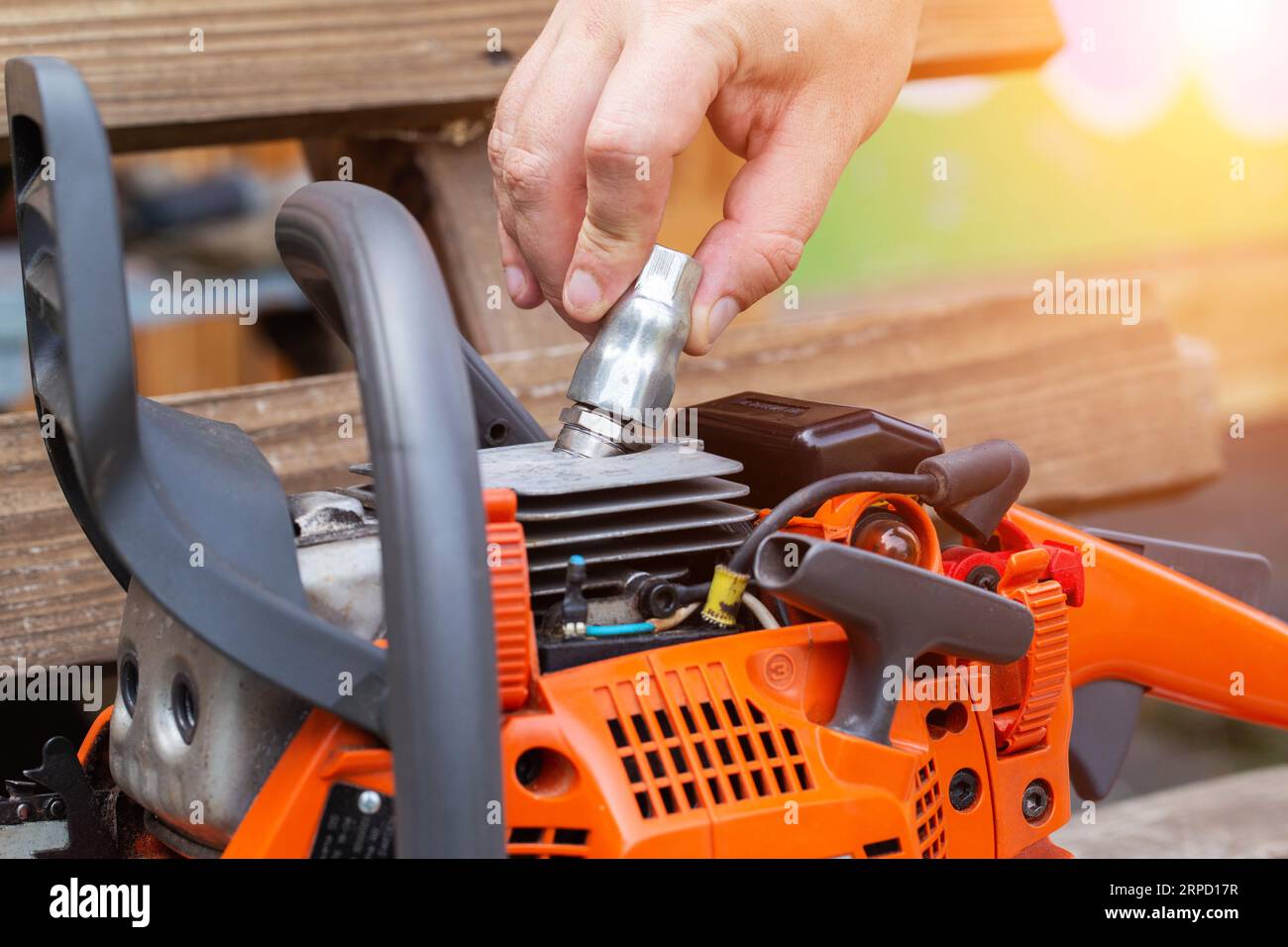 Removing the spark plug from the chainsaw cylinder. Replacing a new