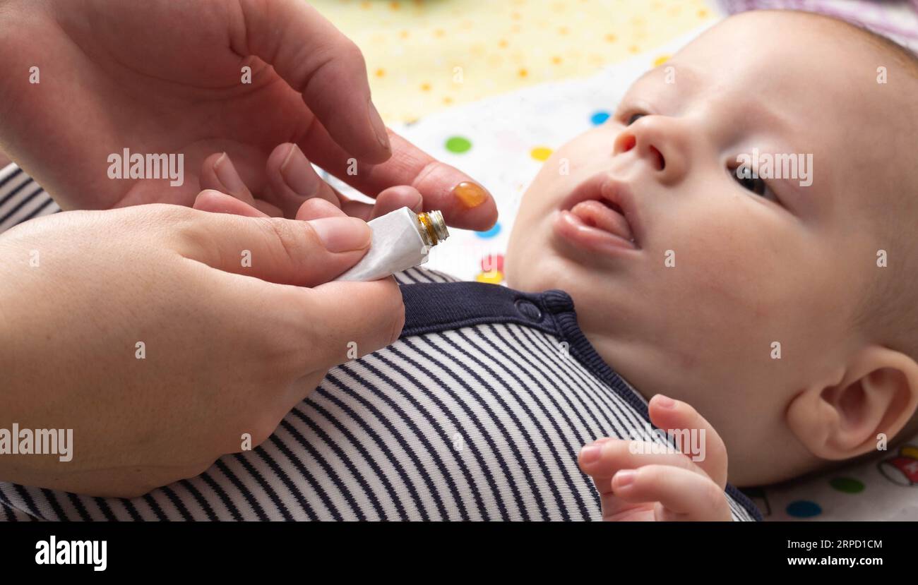 mother applies special anesthetic gel when teething baby Stock Photo Alamy