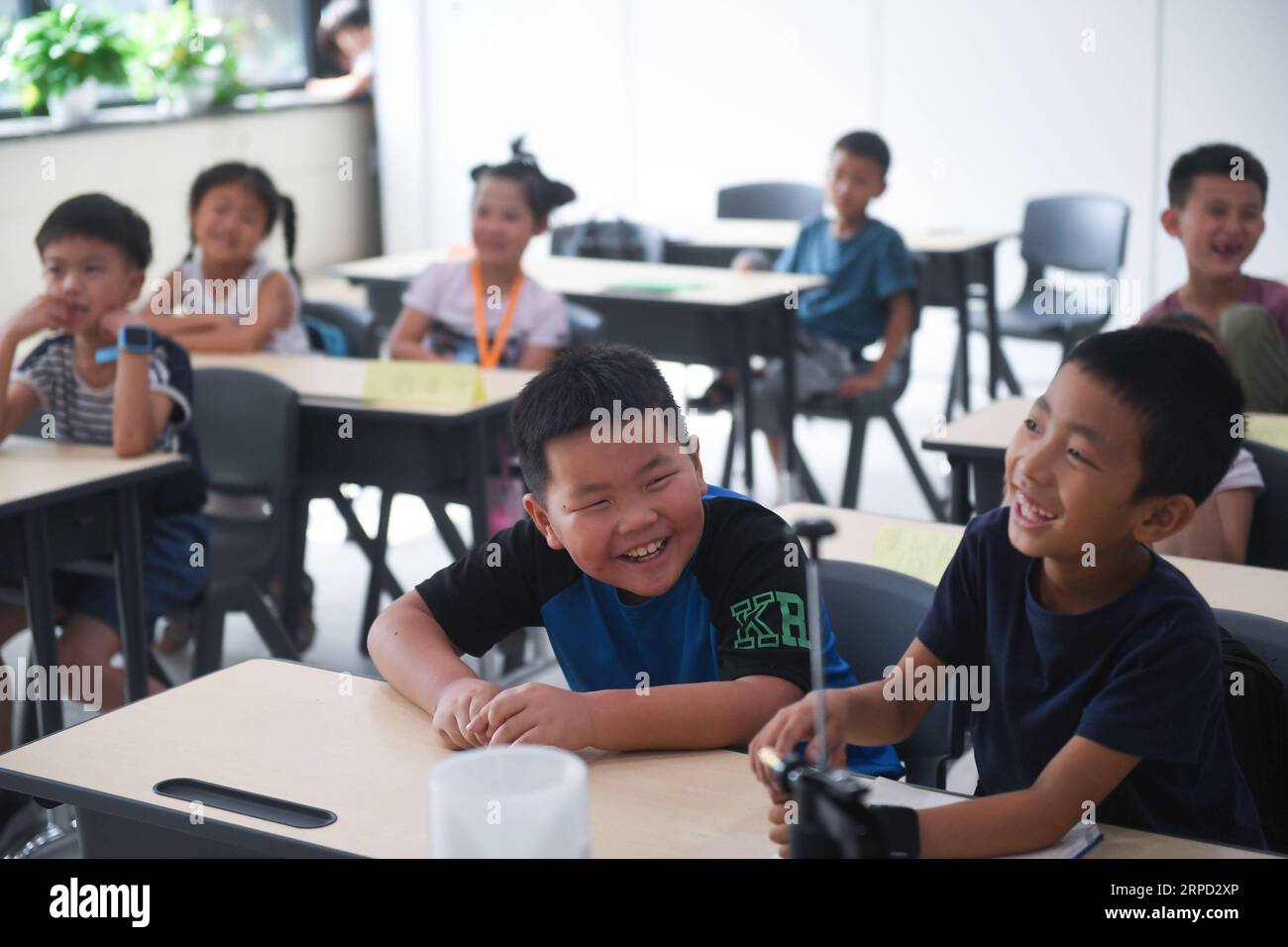 (190720) -- HAINING, July 20, 2019 -- Children attend a lesson as part of a summer camp organized by a local company for the children of its migrant workers in Haining, east China s Zhejiang Province, July 20, 2019. Running for 40 days starting from mid-July, the summer camp invites 180 children whose parents work for the company away from home and thus offers them a chance for family reunion. Besides, the children can expect an enriched summer life here by taking academic, etiquette and sports courses given by university volunteer tutors. ) CHINA-ZHEJIANG-MIGRANT WORKERS-CHILDREN-SUMMER CAMP Stock Photo