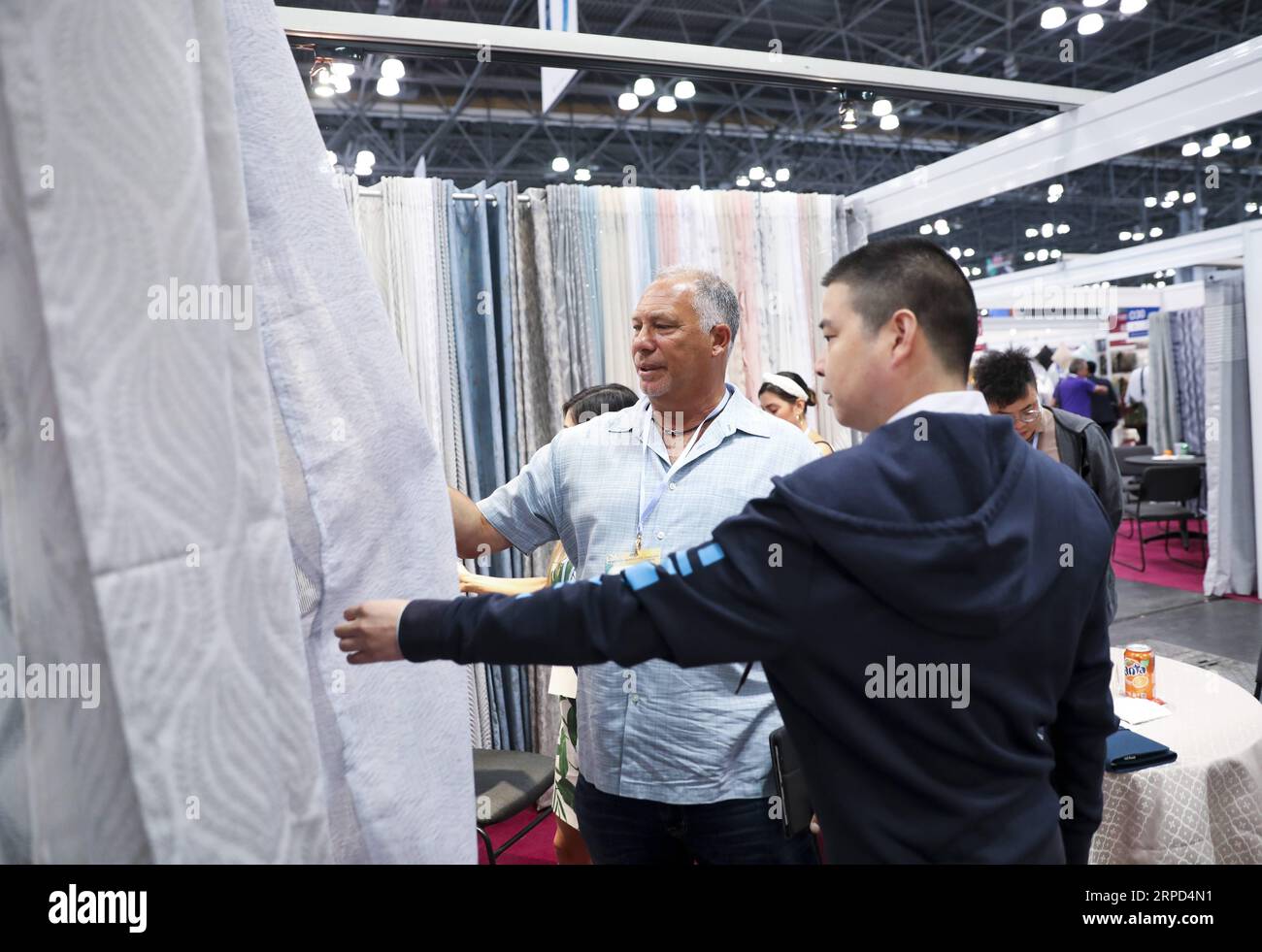 (190722) -- NEW YORK, July 22, 2019 -- Visitors look at fabric samples during the 20th China Textile and Apparel Trade Show in New York, the United States, July 22, 2019. The 20th China Textile and Apparel Trade Show in New York opened on Monday in Manhattan s Javits Center, serving as a platform to showcase the latest industrial trends and help Chinese companies explore the U.S. market. Over 500 Chinese garment, fabric and textile companies are attending this year s trade show, which will run through Wednesday. Another 300 or so companies from 16 countries and regions also joined the show wit Stock Photo