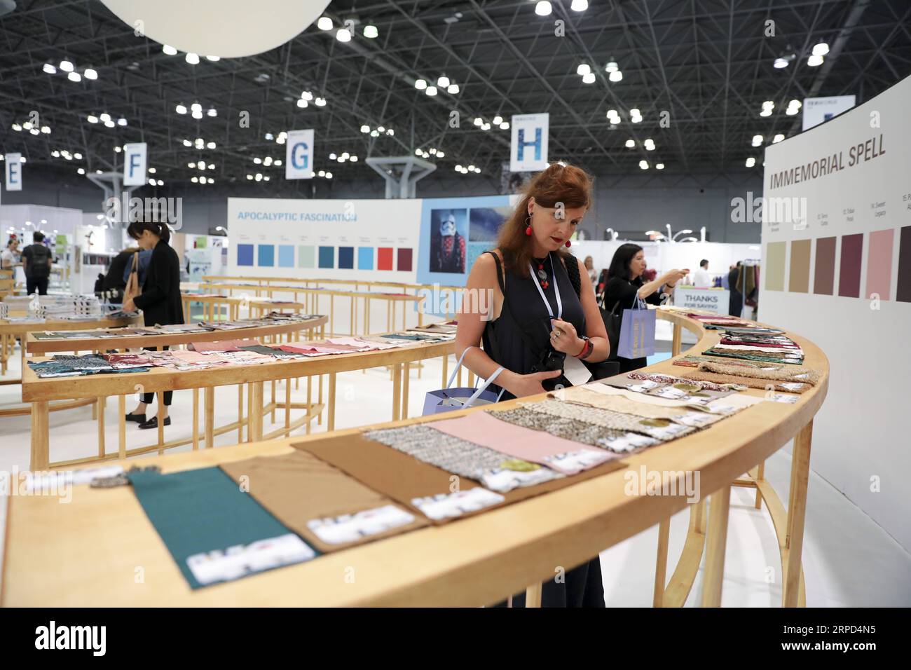 (190722) -- NEW YORK, July 22, 2019 -- Visitors look at exhibits during the 20th China Textile and Apparel Trade Show in New York, the United States, July 22, 2019. The 20th China Textile and Apparel Trade Show in New York opened on Monday in Manhattan s Javits Center, serving as a platform to showcase the latest industrial trends and help Chinese companies explore the U.S. market. Over 500 Chinese garment, fabric and textile companies are attending this year s trade show, which will run through Wednesday. Another 300 or so companies from 16 countries and regions also joined the show with an e Stock Photo