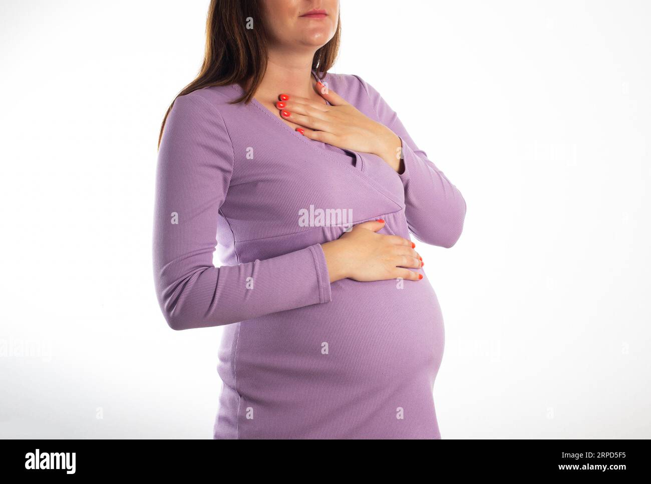 A pregnant girl who has heartburn in her stomach. Reflux of hydrochloric acid into the esophagus. Heartburn in pregnancy. Hormonal background Stock Photo