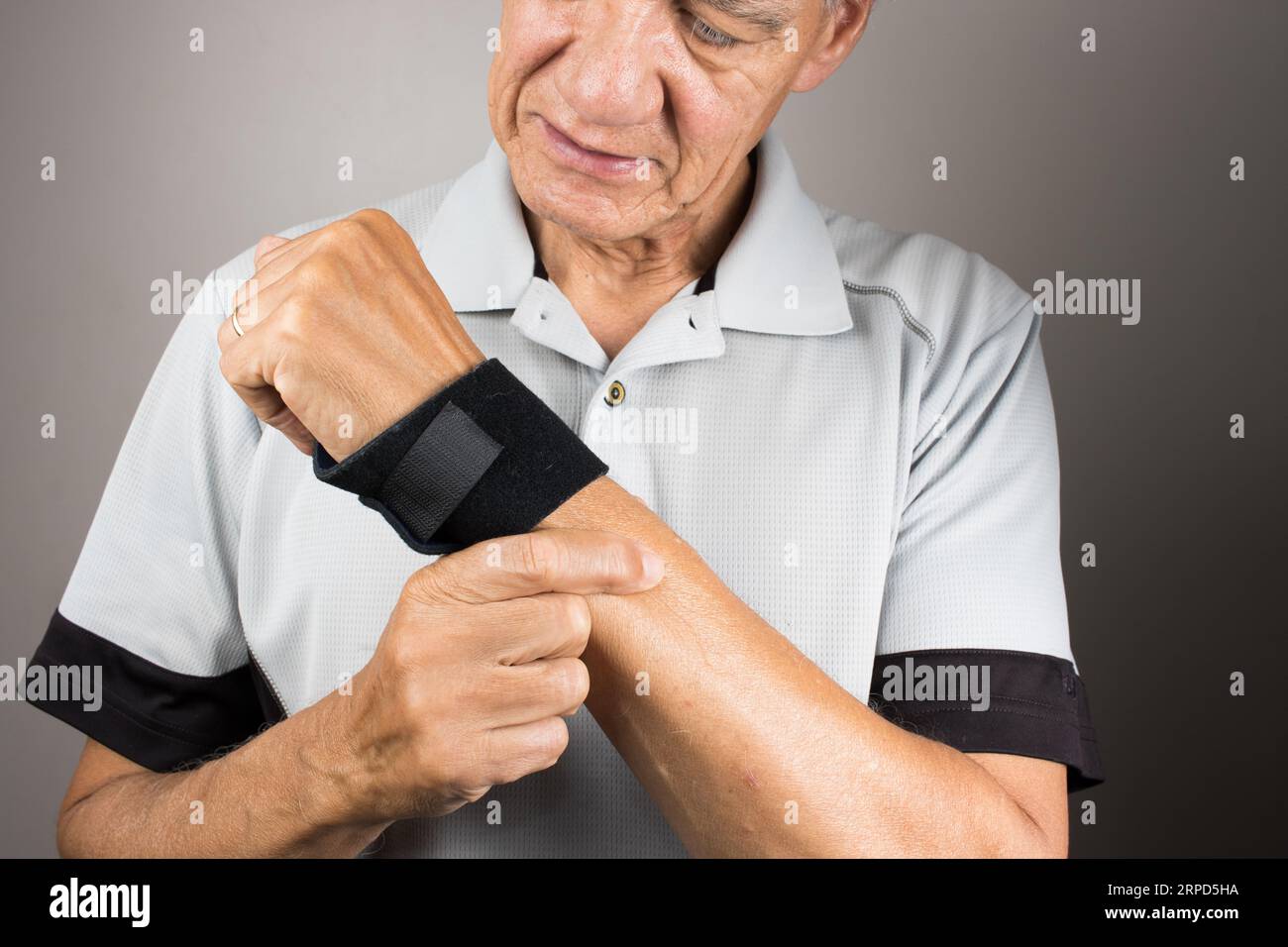 A closeup of a man wearing a wrist brace on his left hand and wrist for