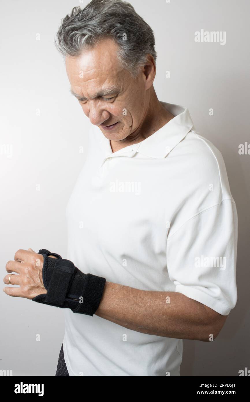 A Hispanic man wearing a wrist brace on his left hand for pain