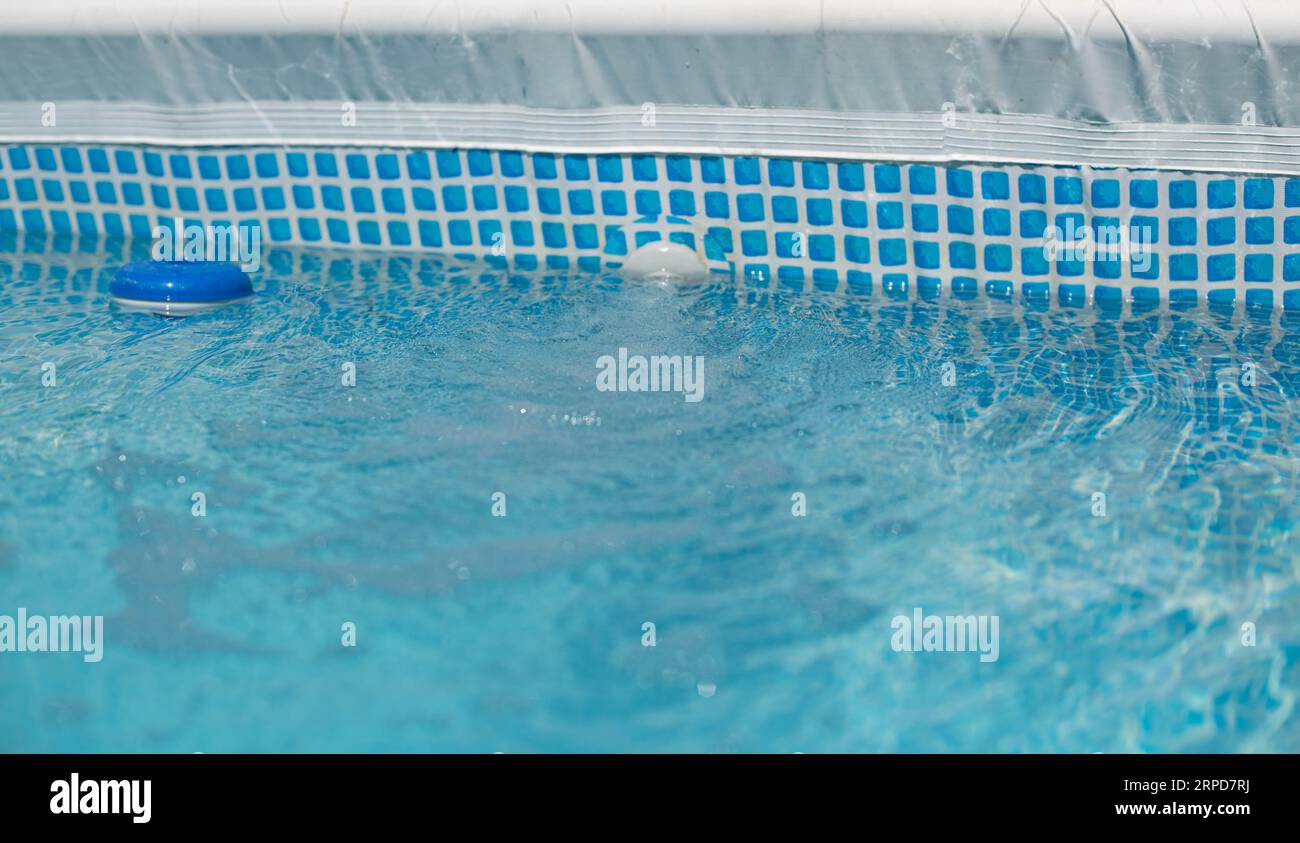 Chlorine floating chlorine dispenser for the treatment of water in swimming pools in the summer bathing season Stock Photo