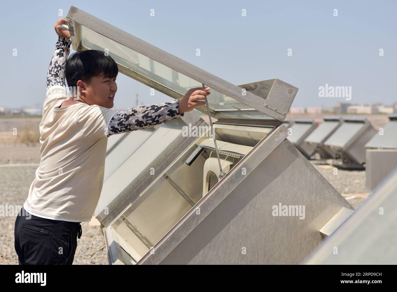 (190727) -- TURPAN, July 27, 2019 -- Inspector You Liwu arranges a test chamber simulating internal environment of vehicles on a large patch of land of the Xinjiang Turpan Natural Environment Experimental Research Center in Turpan, northwest China s Xinjiang Uygur Autonomous Region, July 17, 2019. You Liwu, 26, has been an outdoor-exposure test inspector of the Xinjiang Turpan Natural Environment Experimental Research Center since graduation two year ago. His work is to inspect test items and monitor and gather data, who would be exposed to the torrid test land for up to five hours every day. Stock Photo